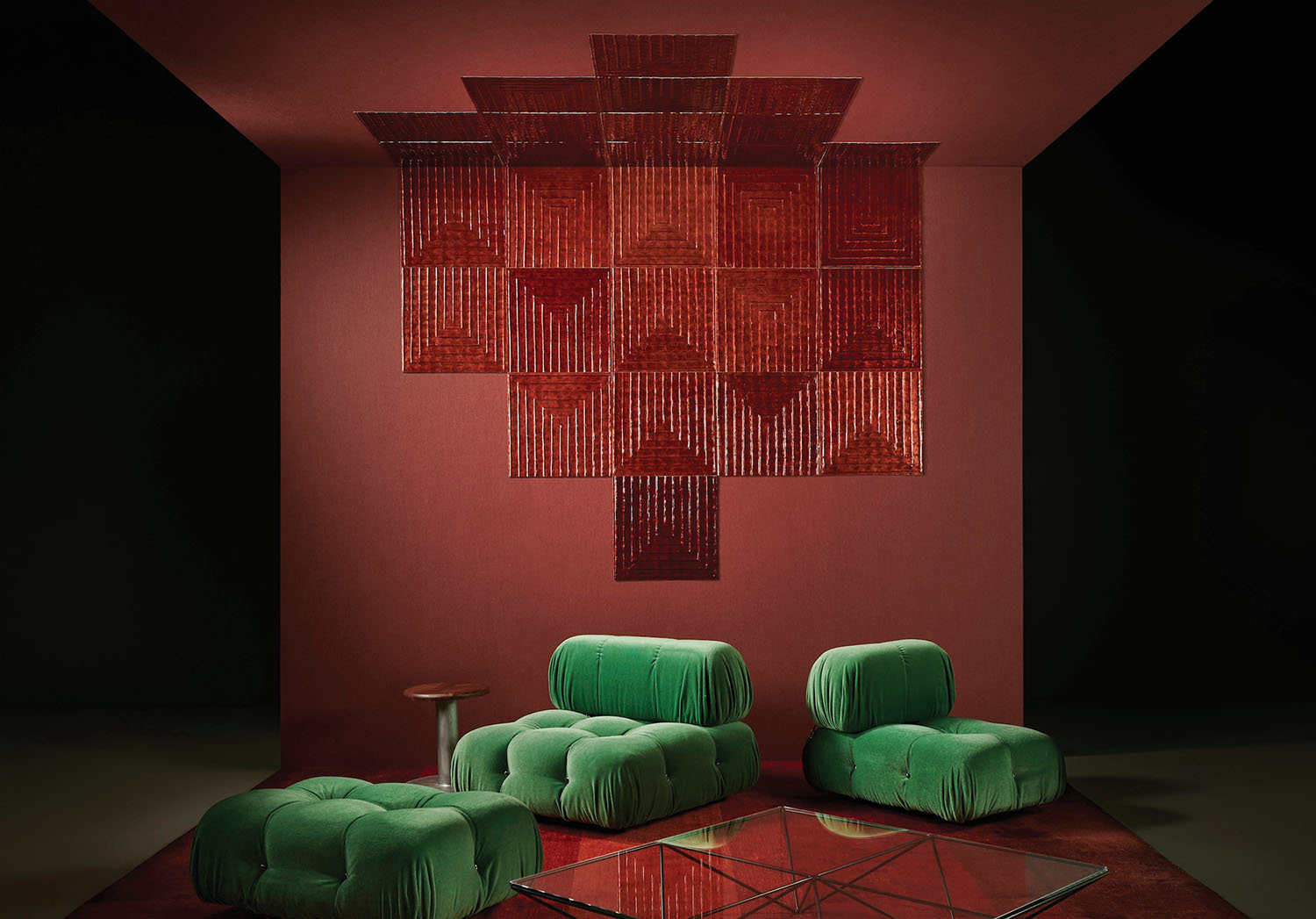 A room with a red wall and green chairs.