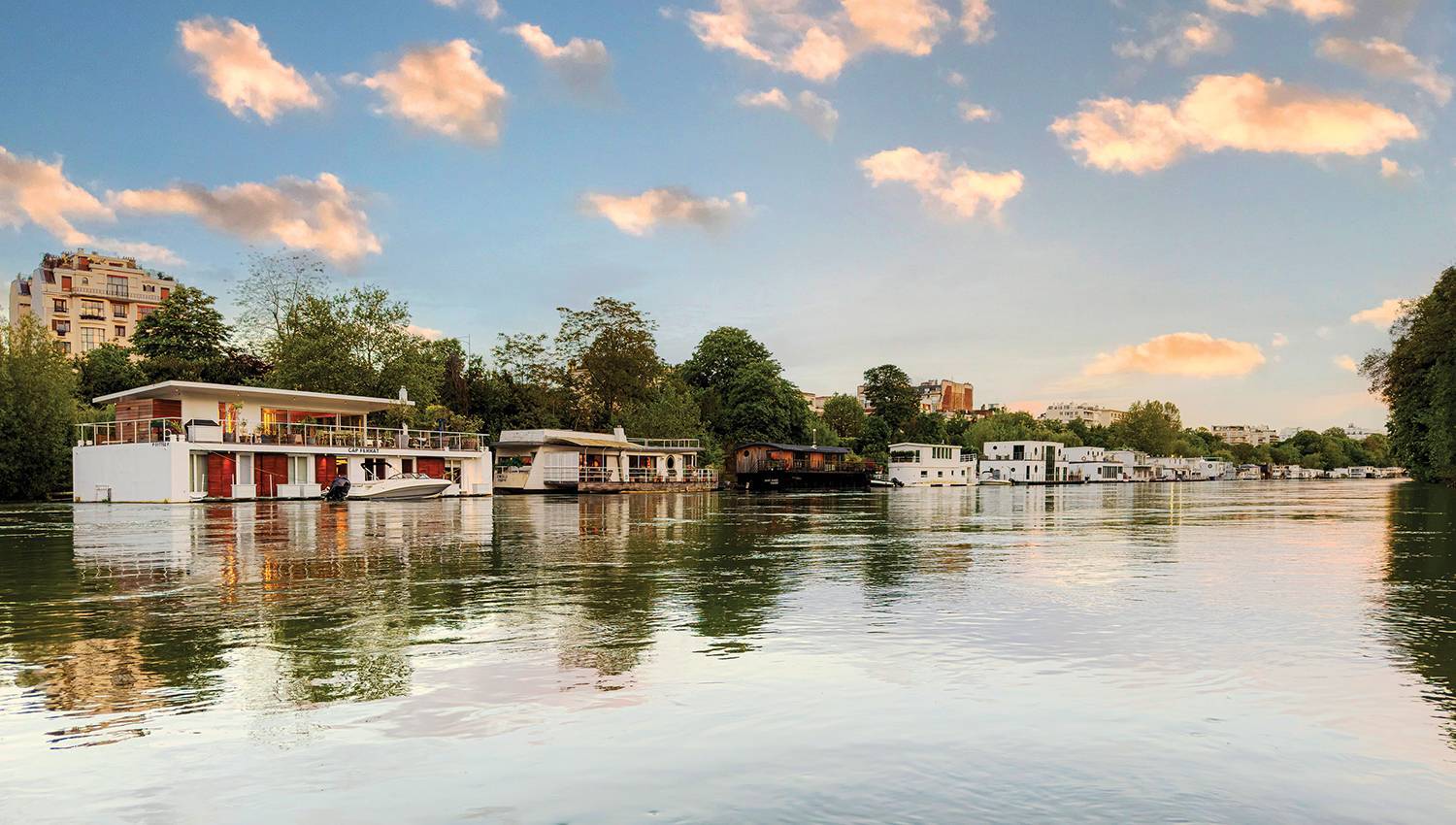 A river with boats and houses in the background