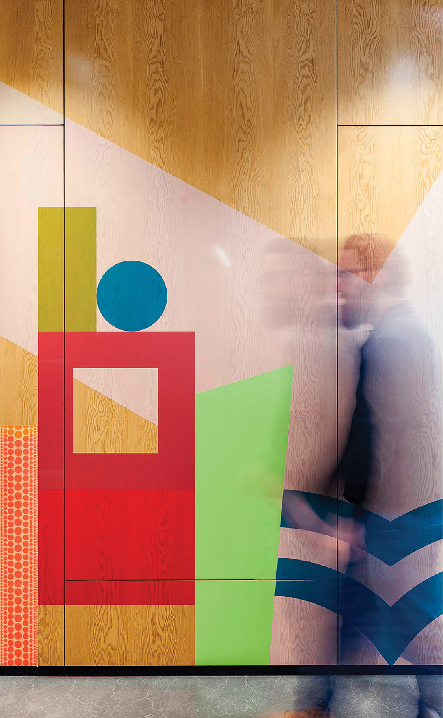 A man walking past a colorful wall mural