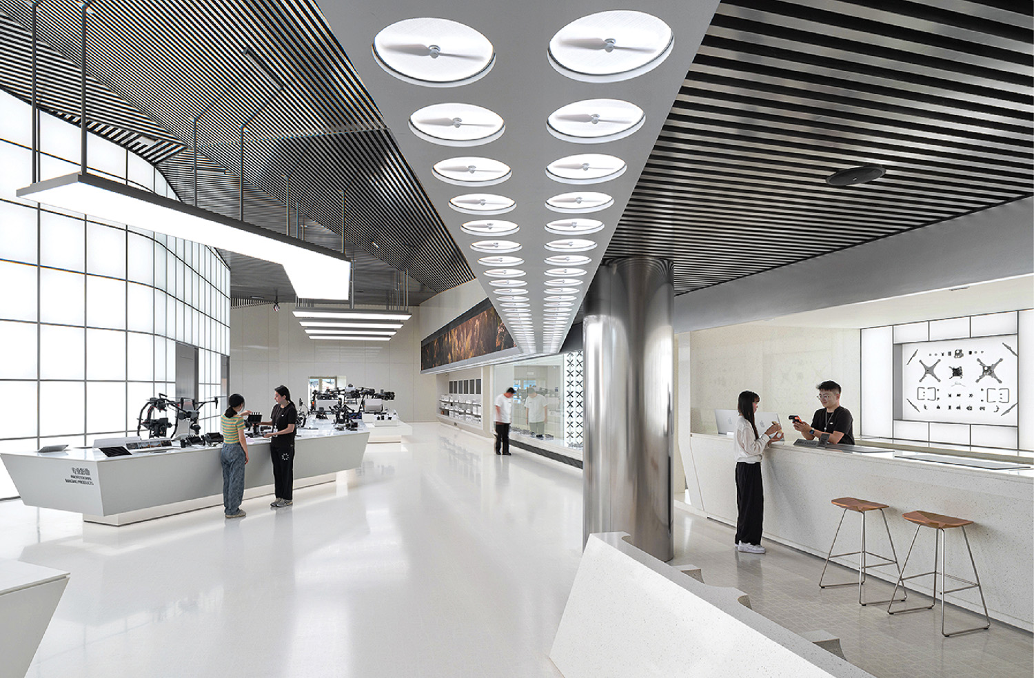 people around a white counter and underneath white fluorescent lights