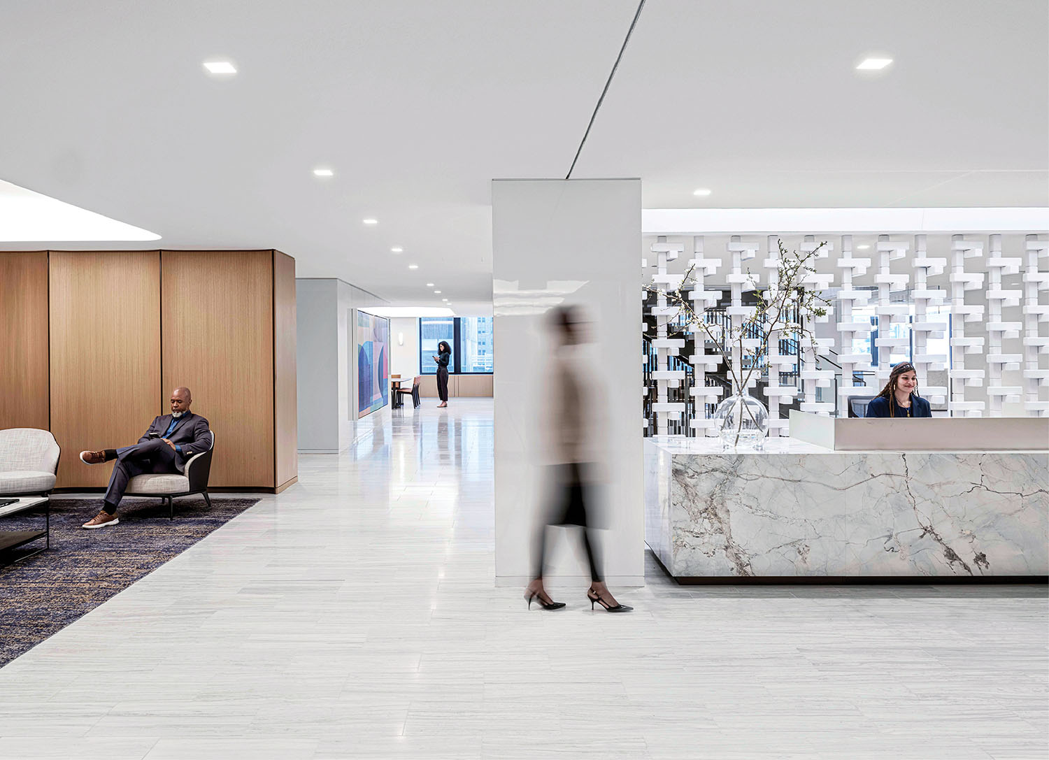 A lobby with a marble reception desk and a large.