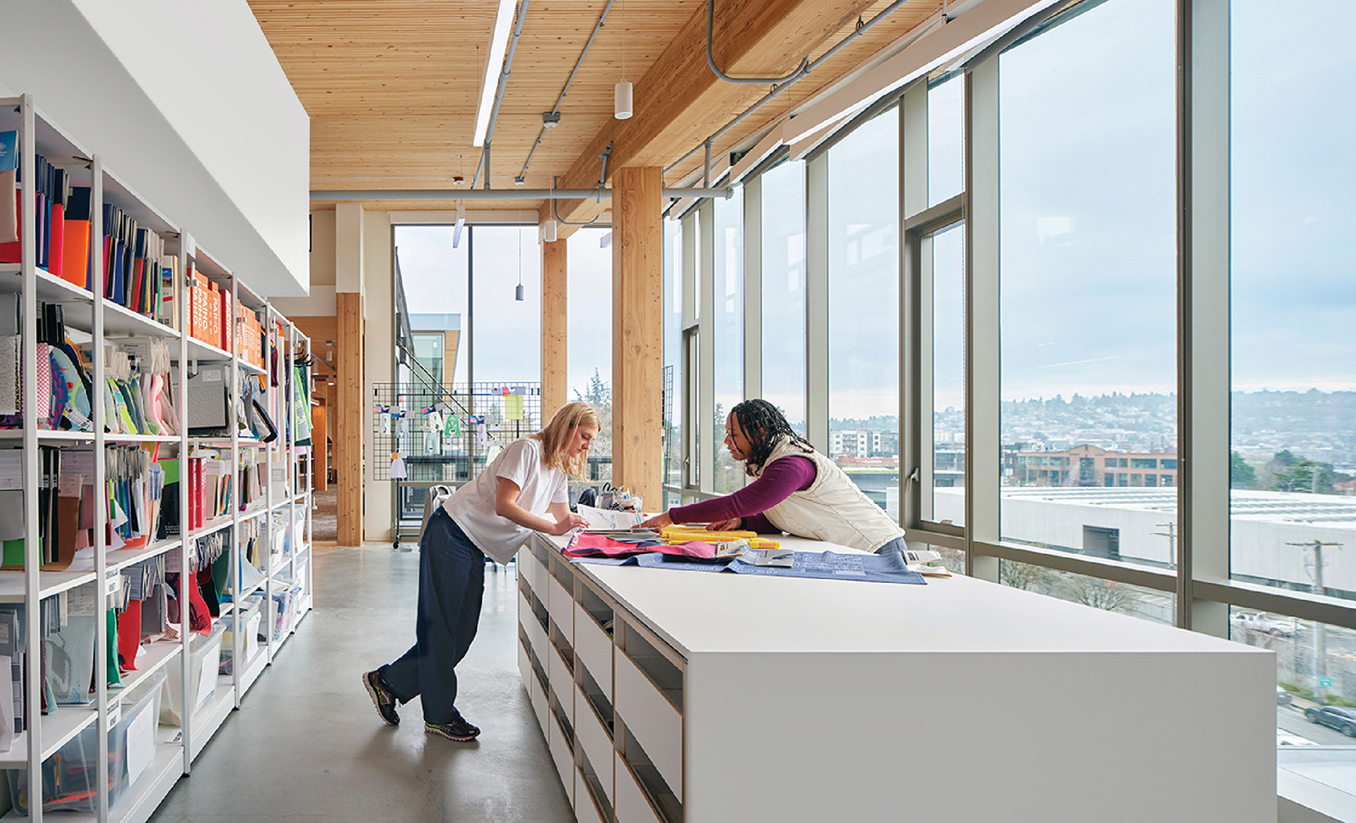 A woman is sitting at a desk in a library