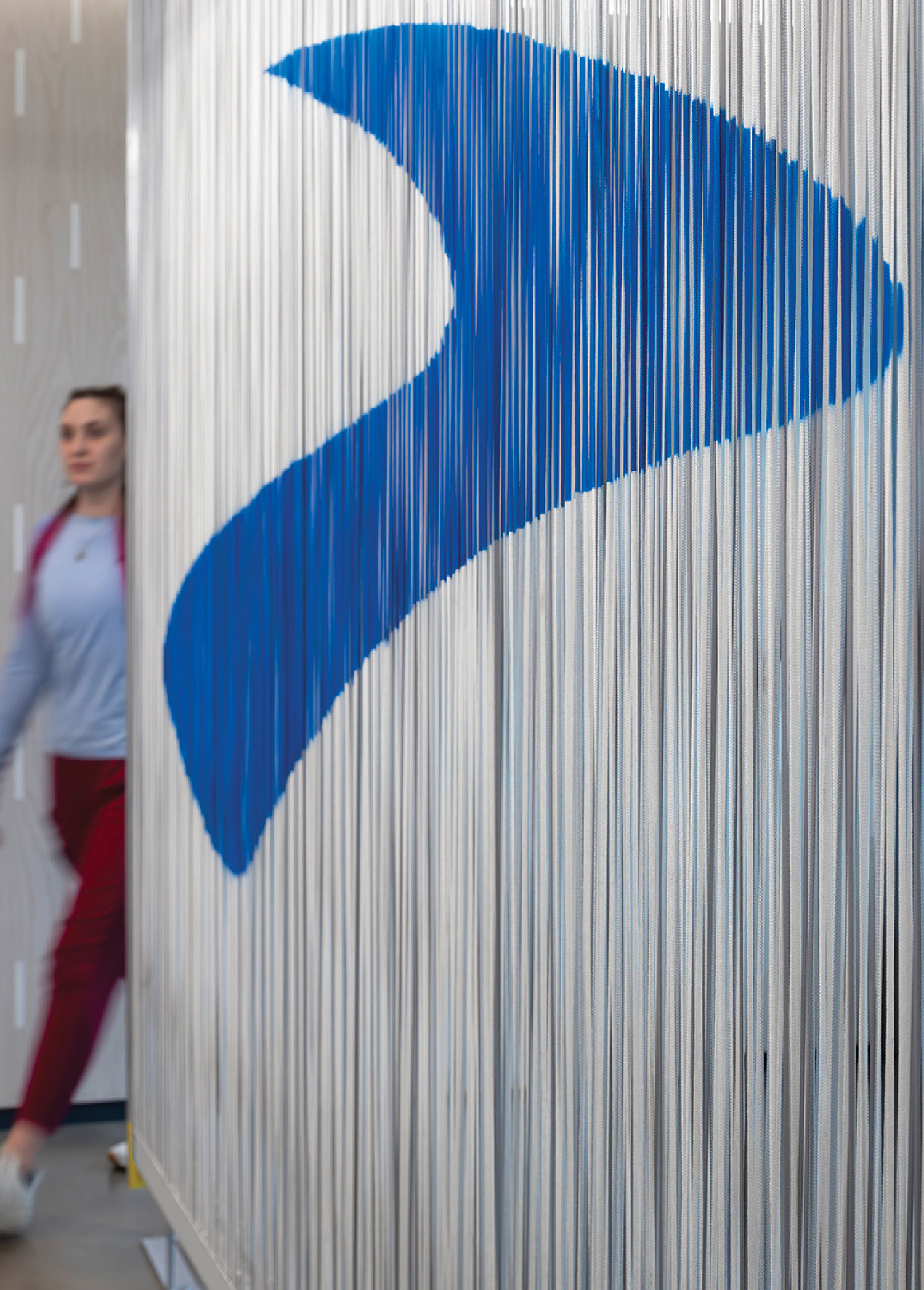 A man walking past a blue and white sign