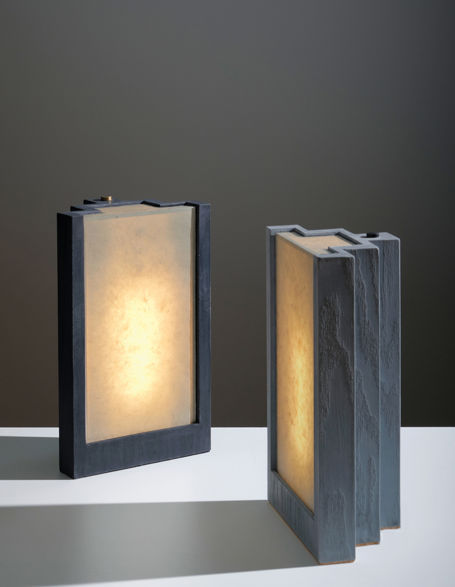 Two lamps on a table with a white surface.