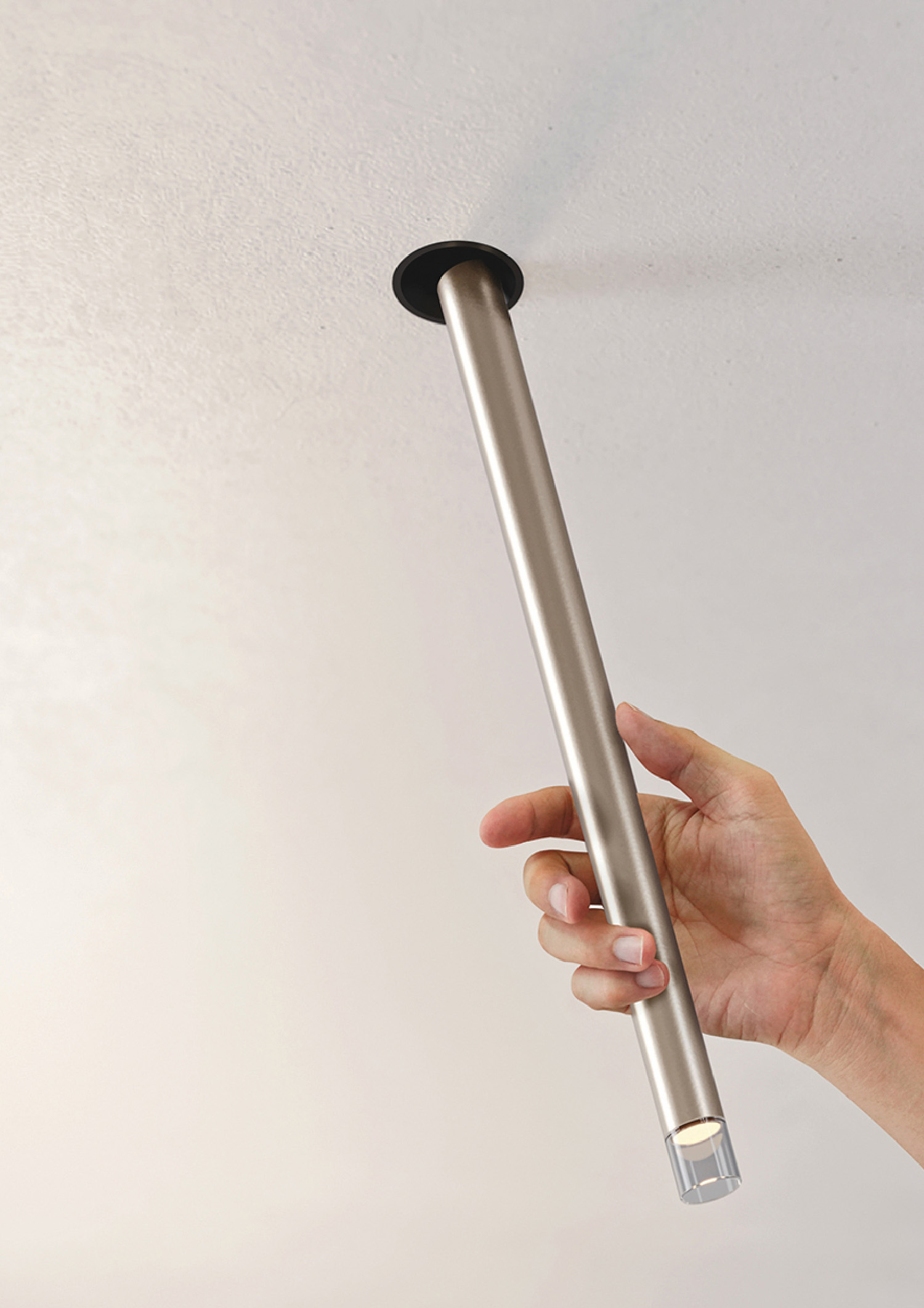 A hand holding a silver metal object.