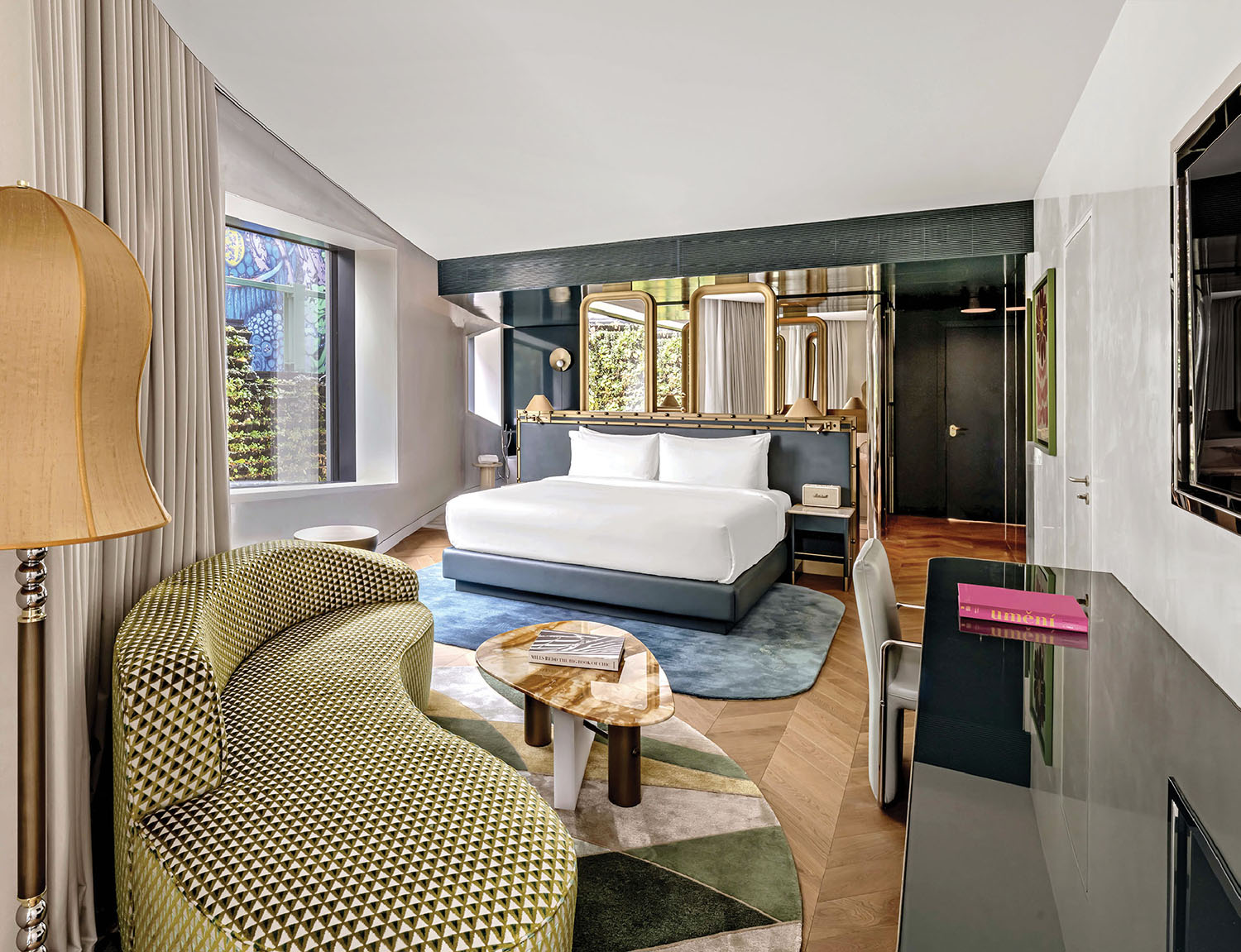 A bedroom with a bed, chair and television.