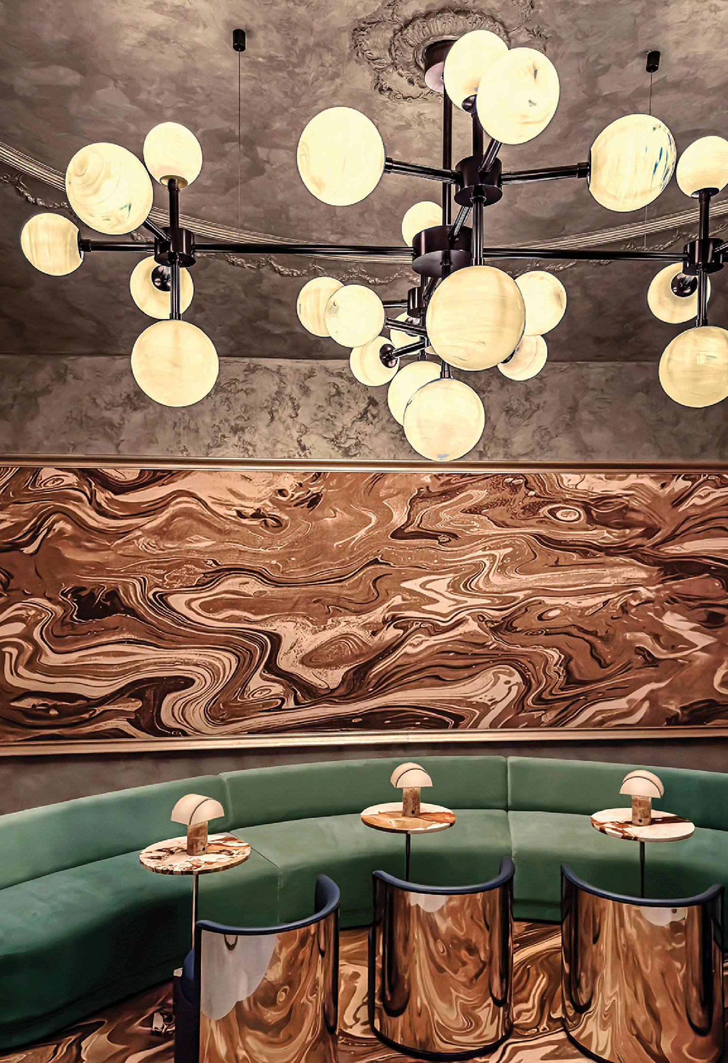 A restaurant with a circular table and a green couch.