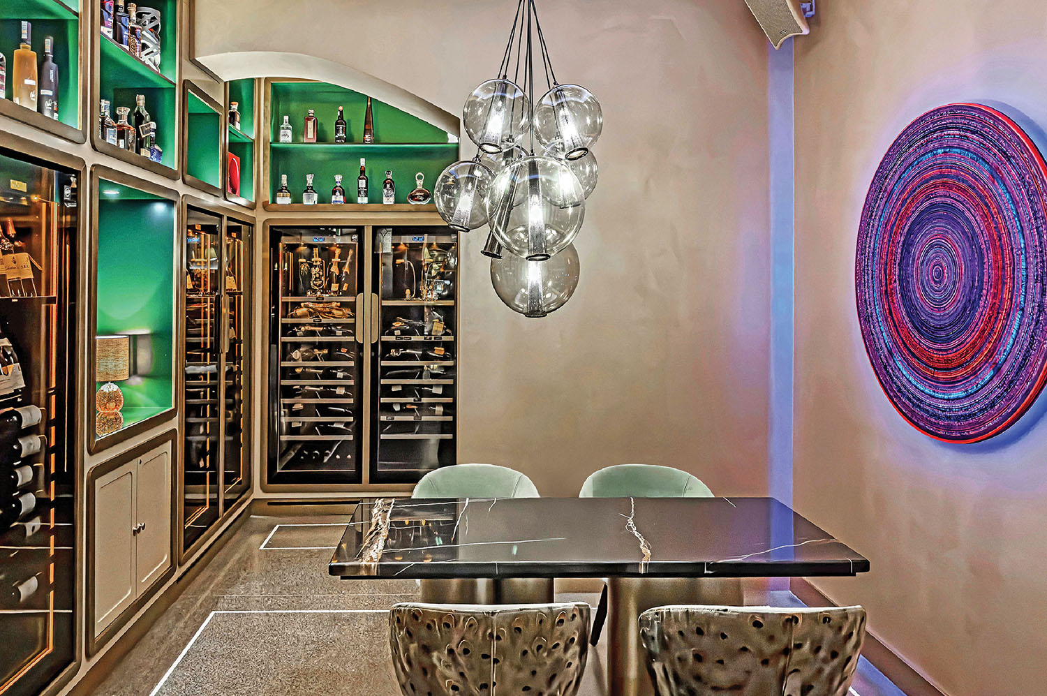 A room with a table and chairs and a wall with a circular artwor.