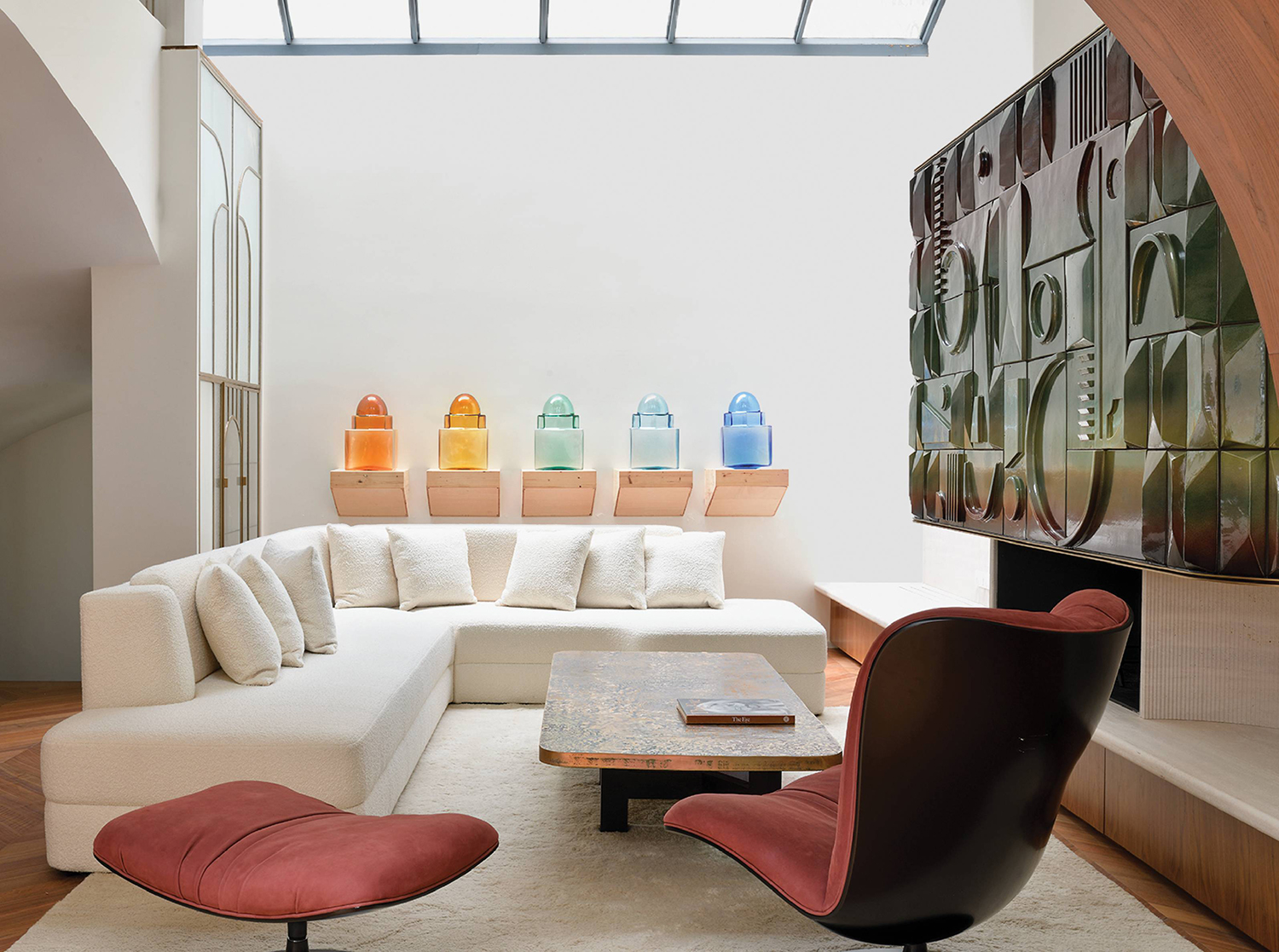 A living room with a white couch and a red chair