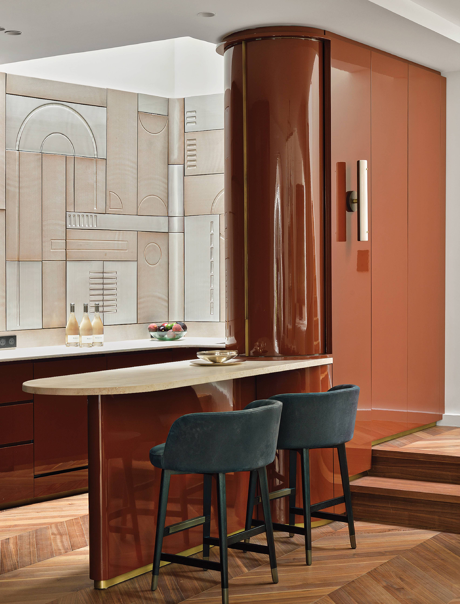 A kitchen with a large red refrigerator and a bar stool