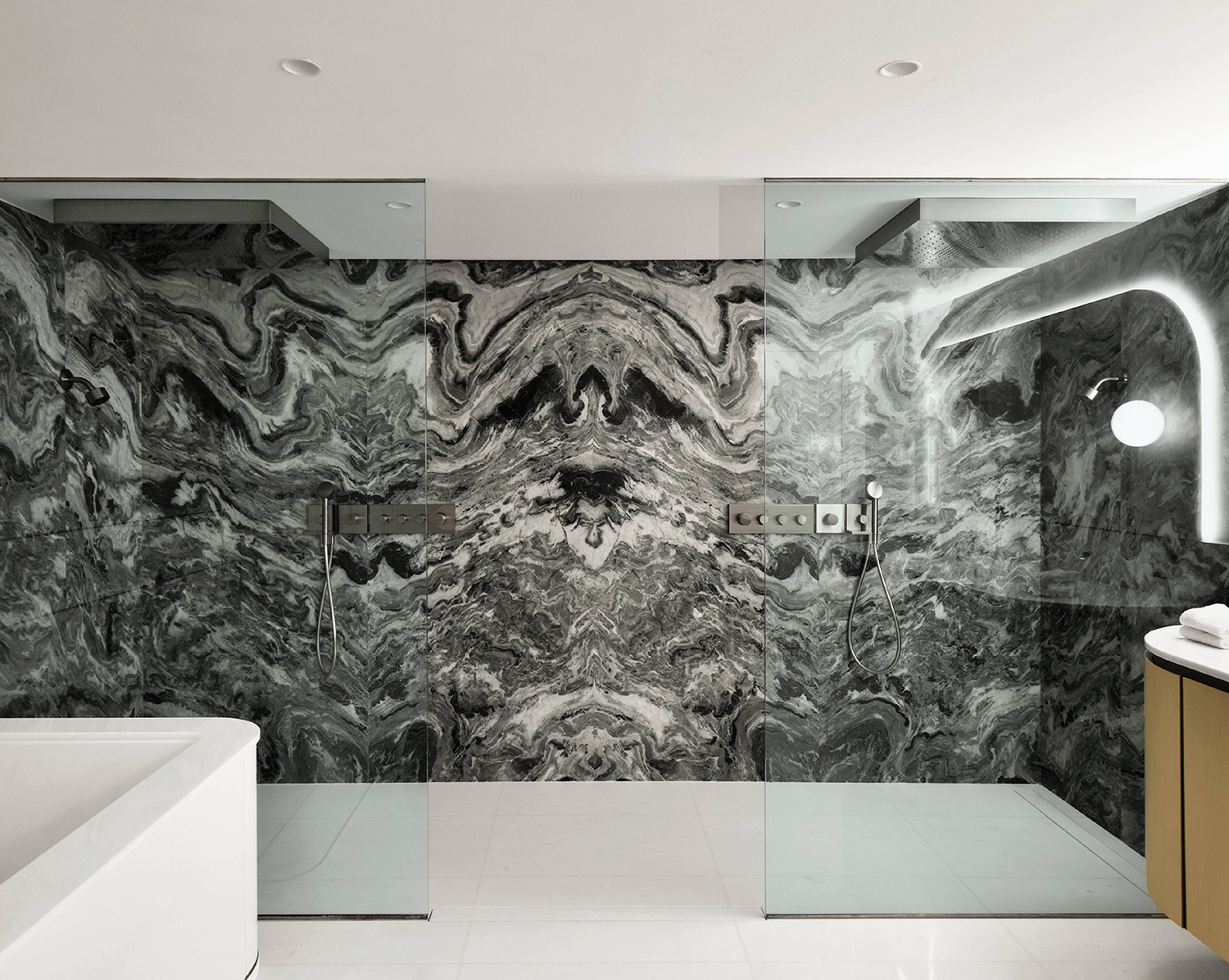 A bathroom with a marble wall and a sink