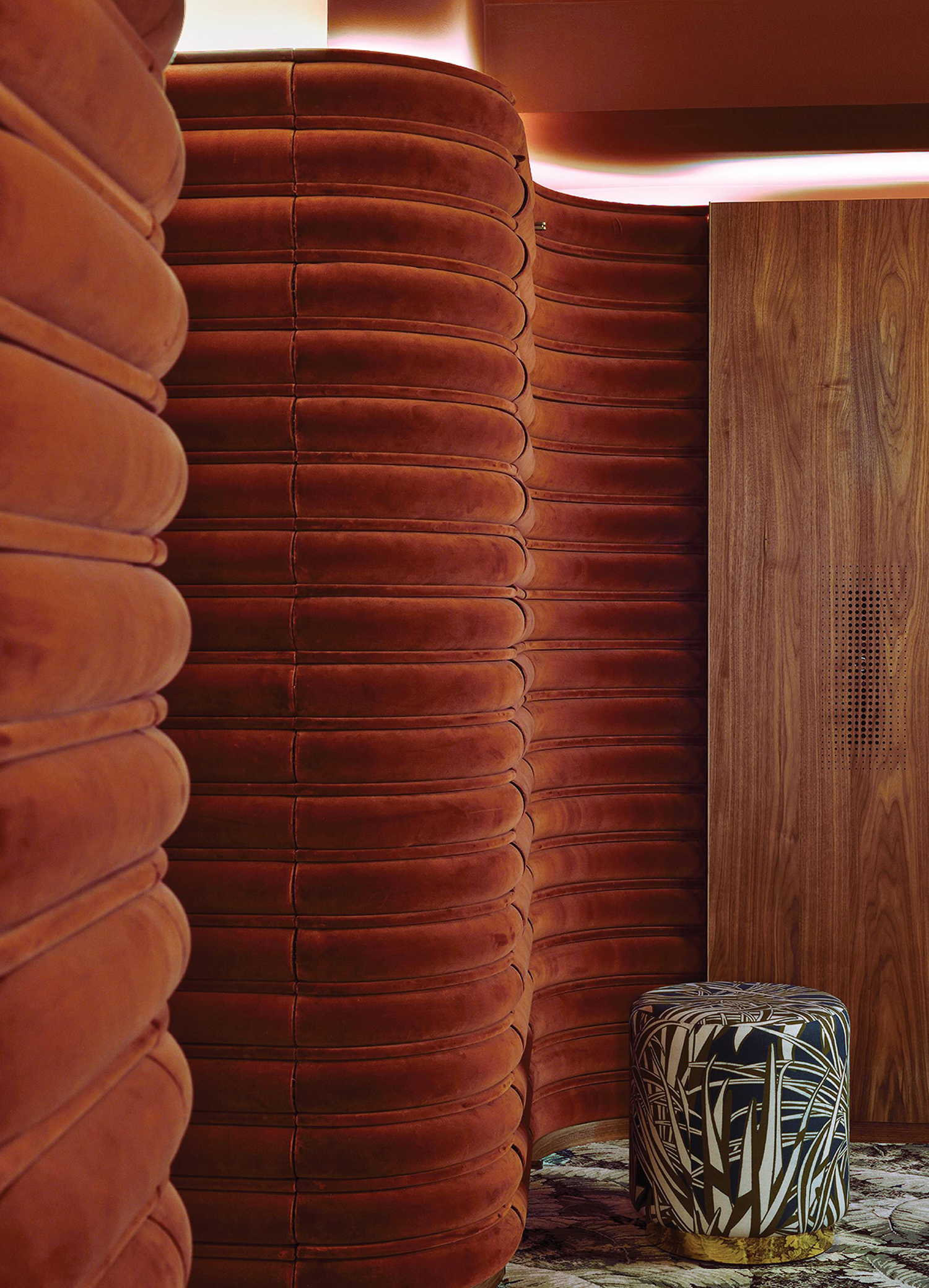 A room with a large wooden wall and a stool