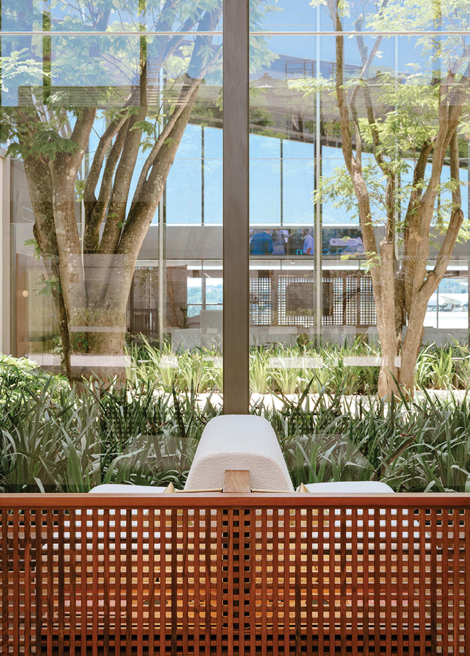A bench with a cushion on it in front of a window