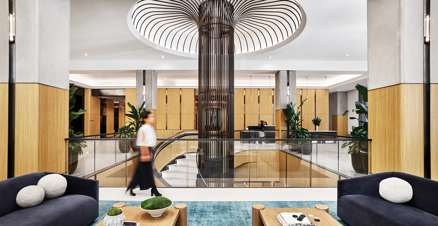 A man walking through a living room with a large lamp