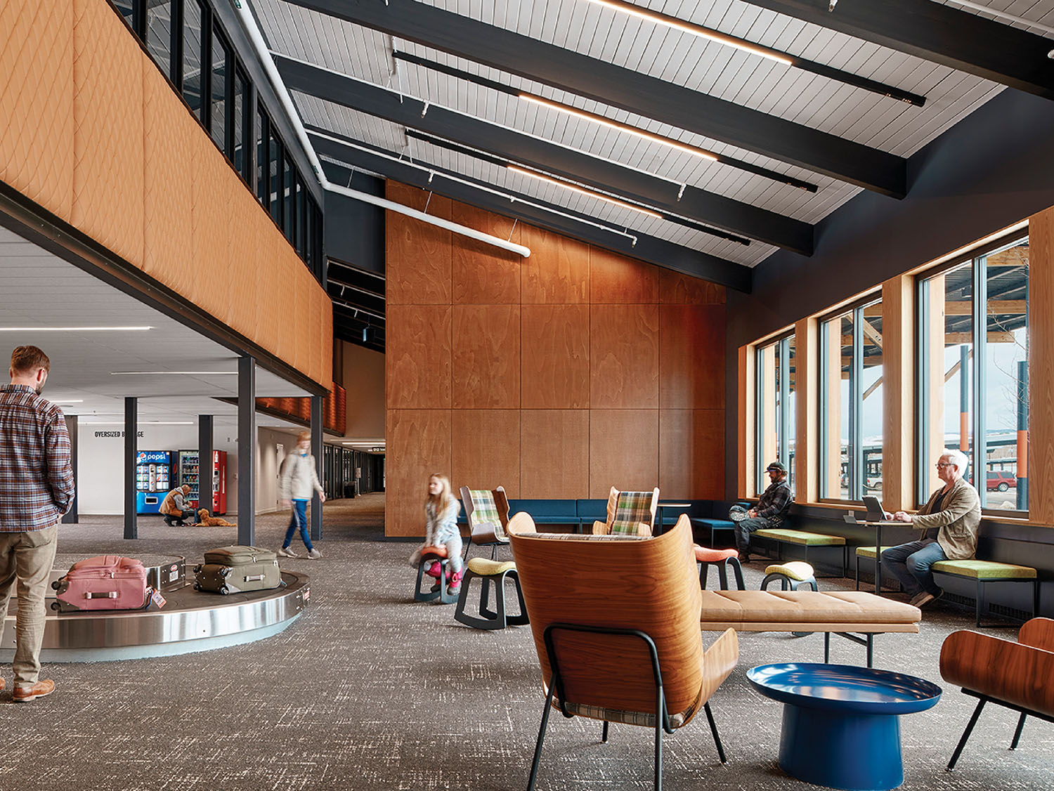 A man walking through a lobby with a large window