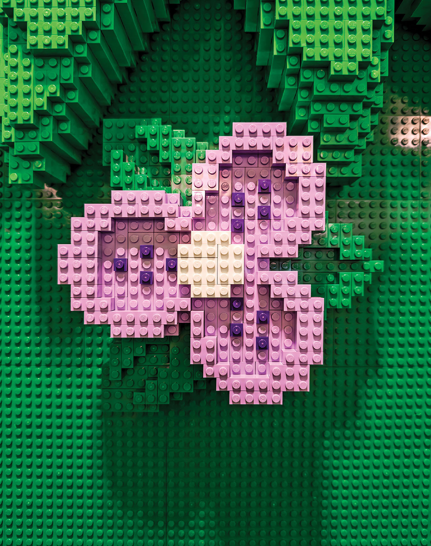 A lego plant with a purple flower on it.