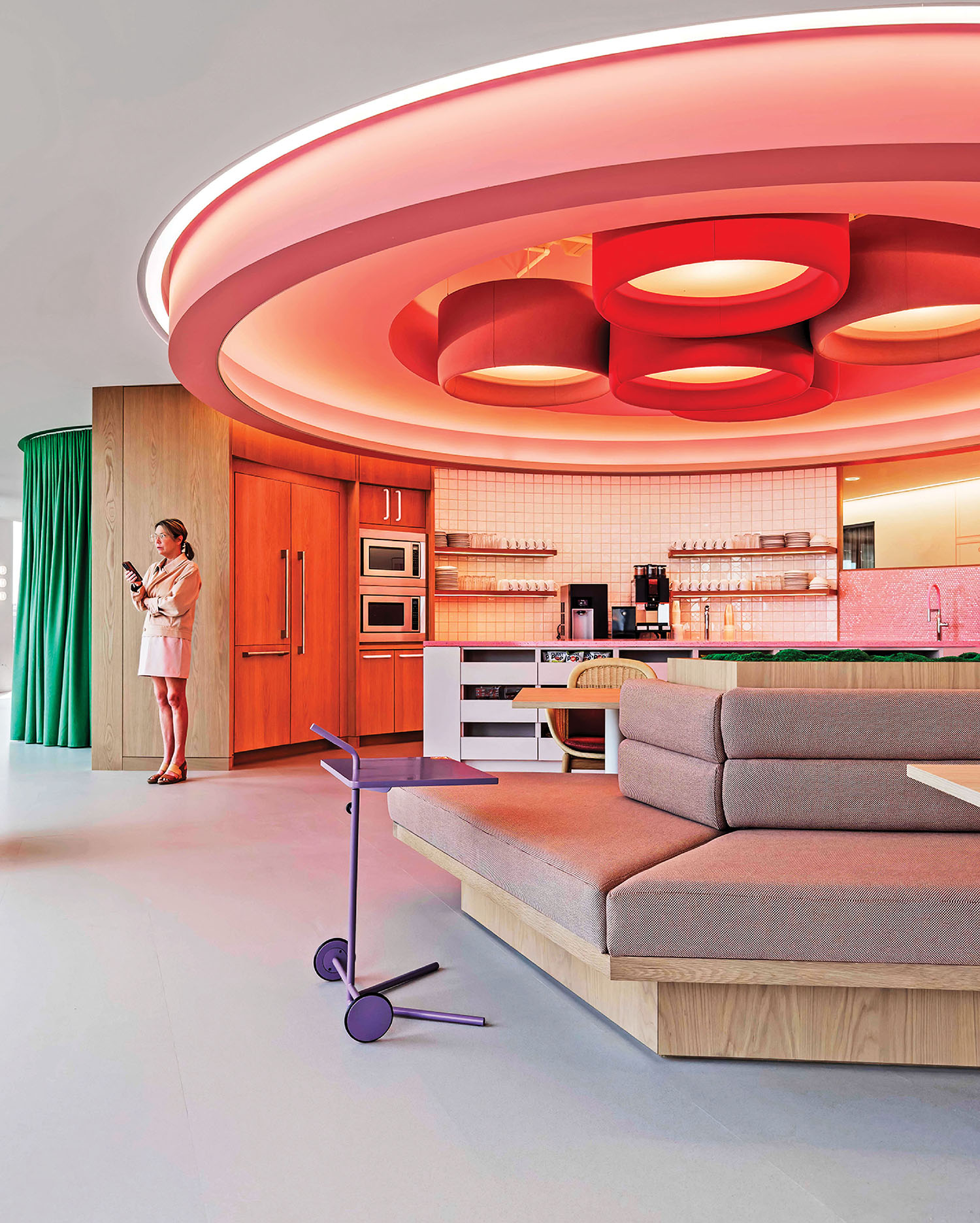 A woman standing in a living room with a couch.