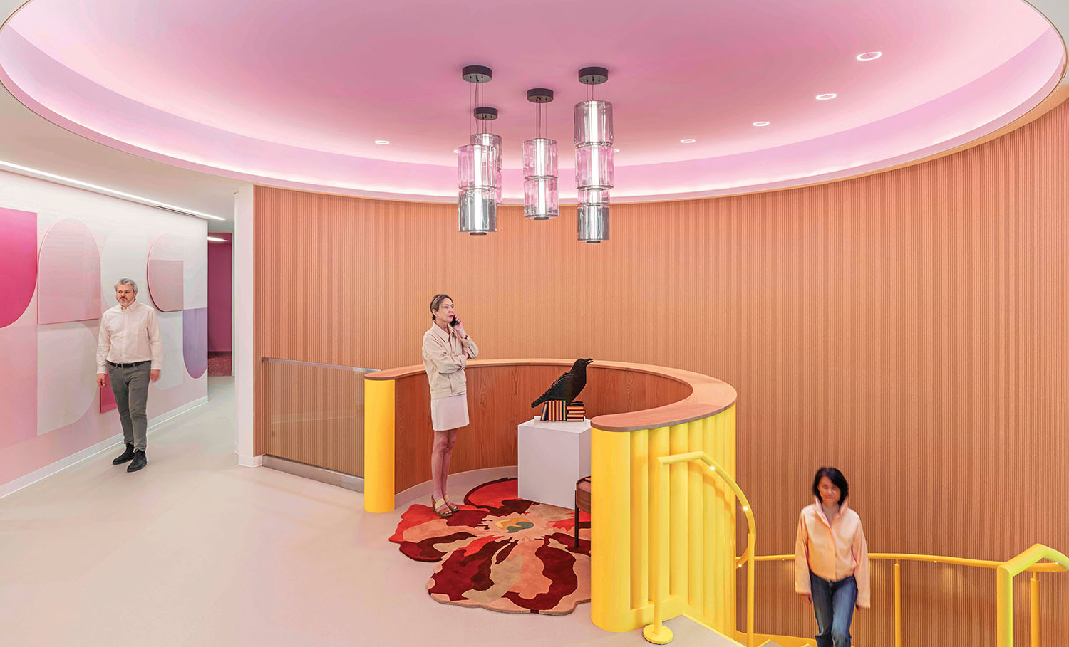 A woman standing in a pink and yellow lobby.