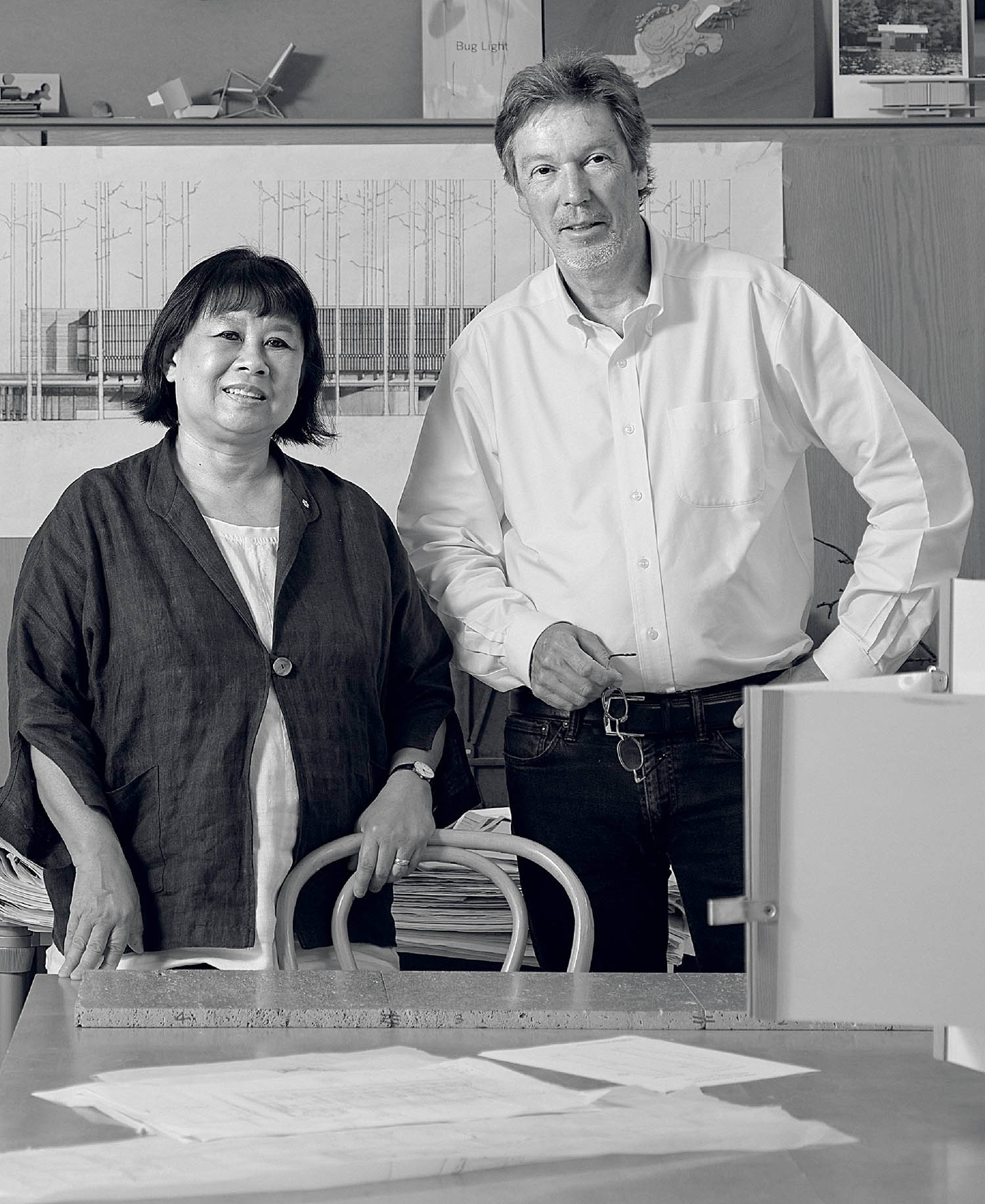 A man and woman standing in front of a desk.