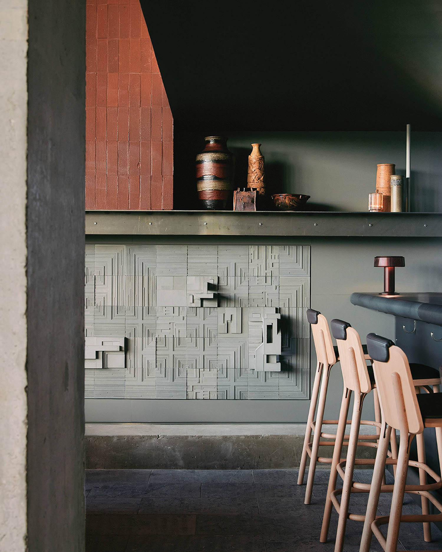A kitchen with a counter and stools.