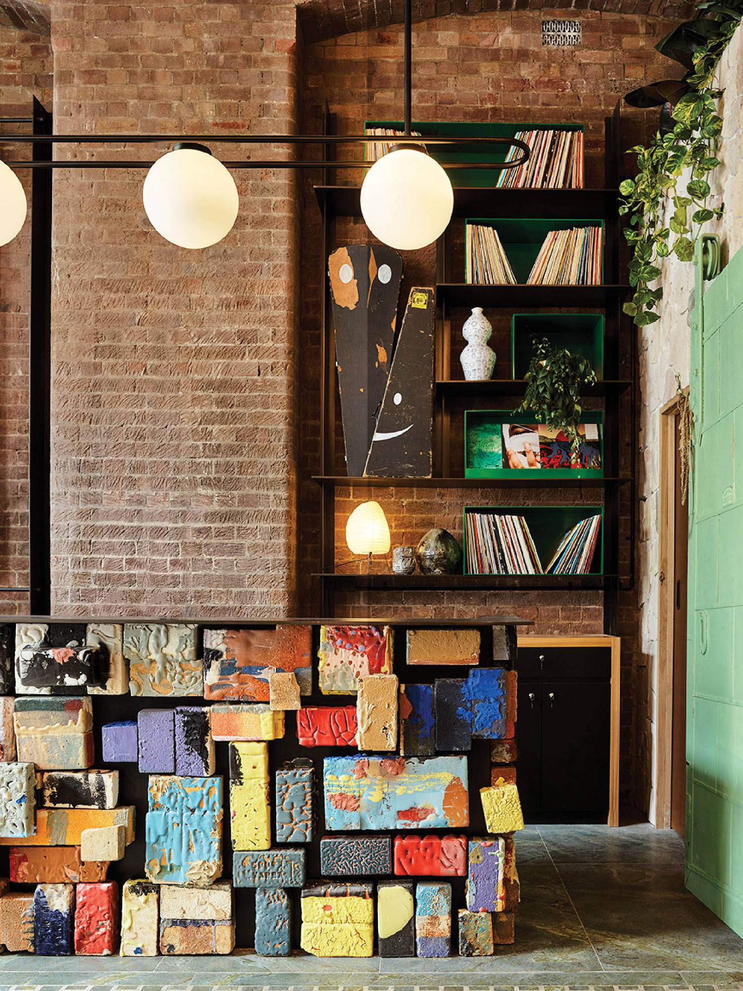 A room with a large pile of books and a lamp.