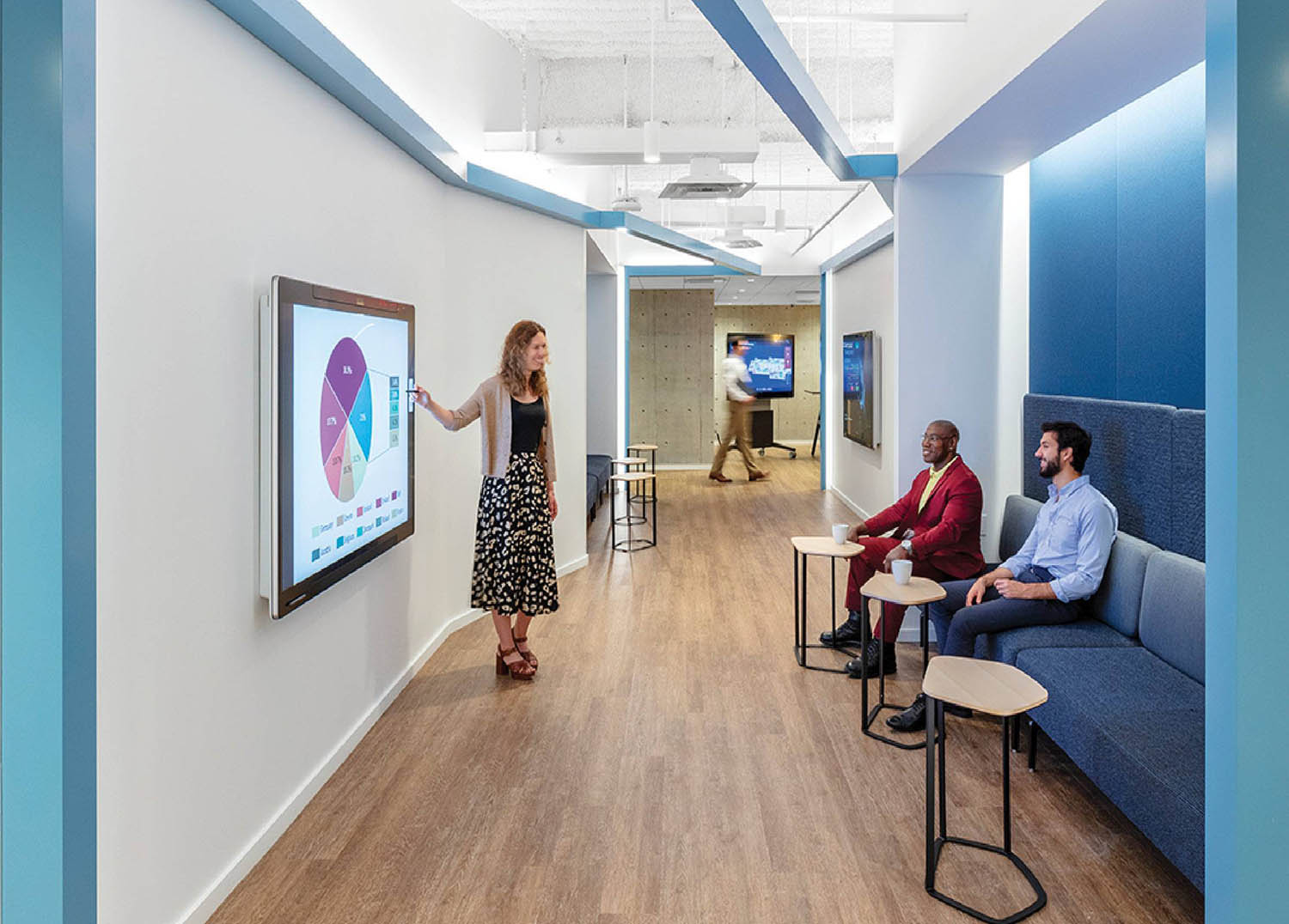A woman is standing in a room with a project on the wall.