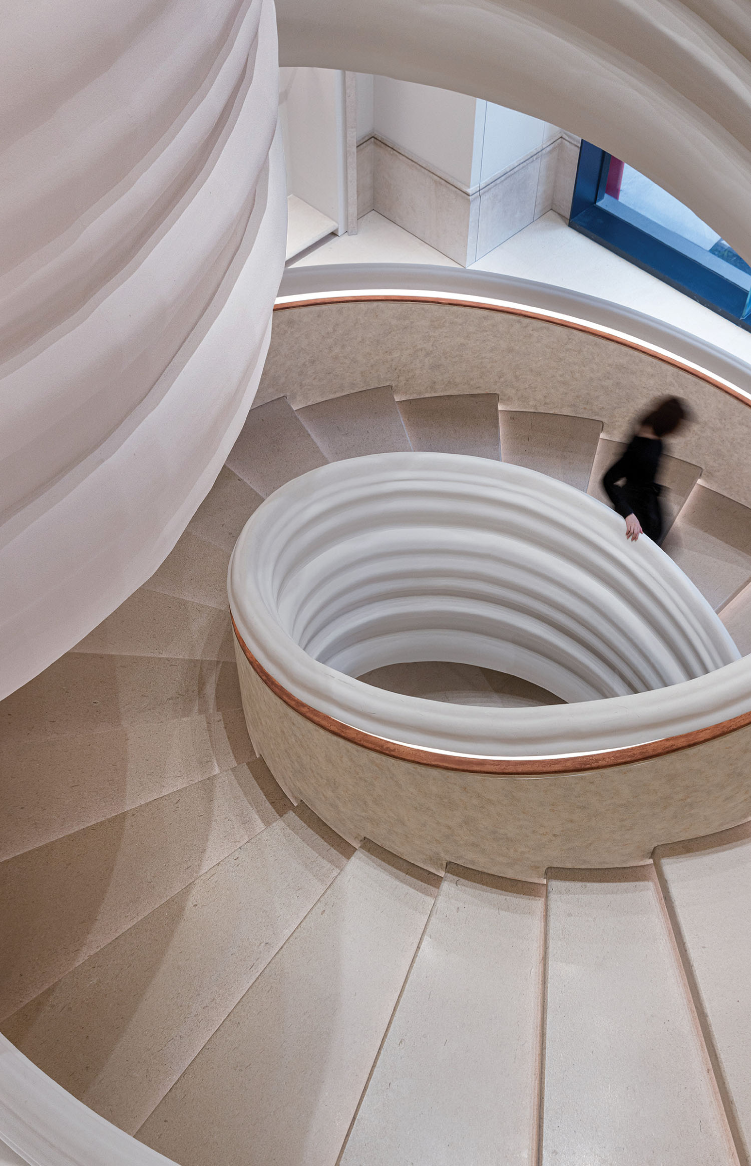 A person walking up a spiral staircase.
