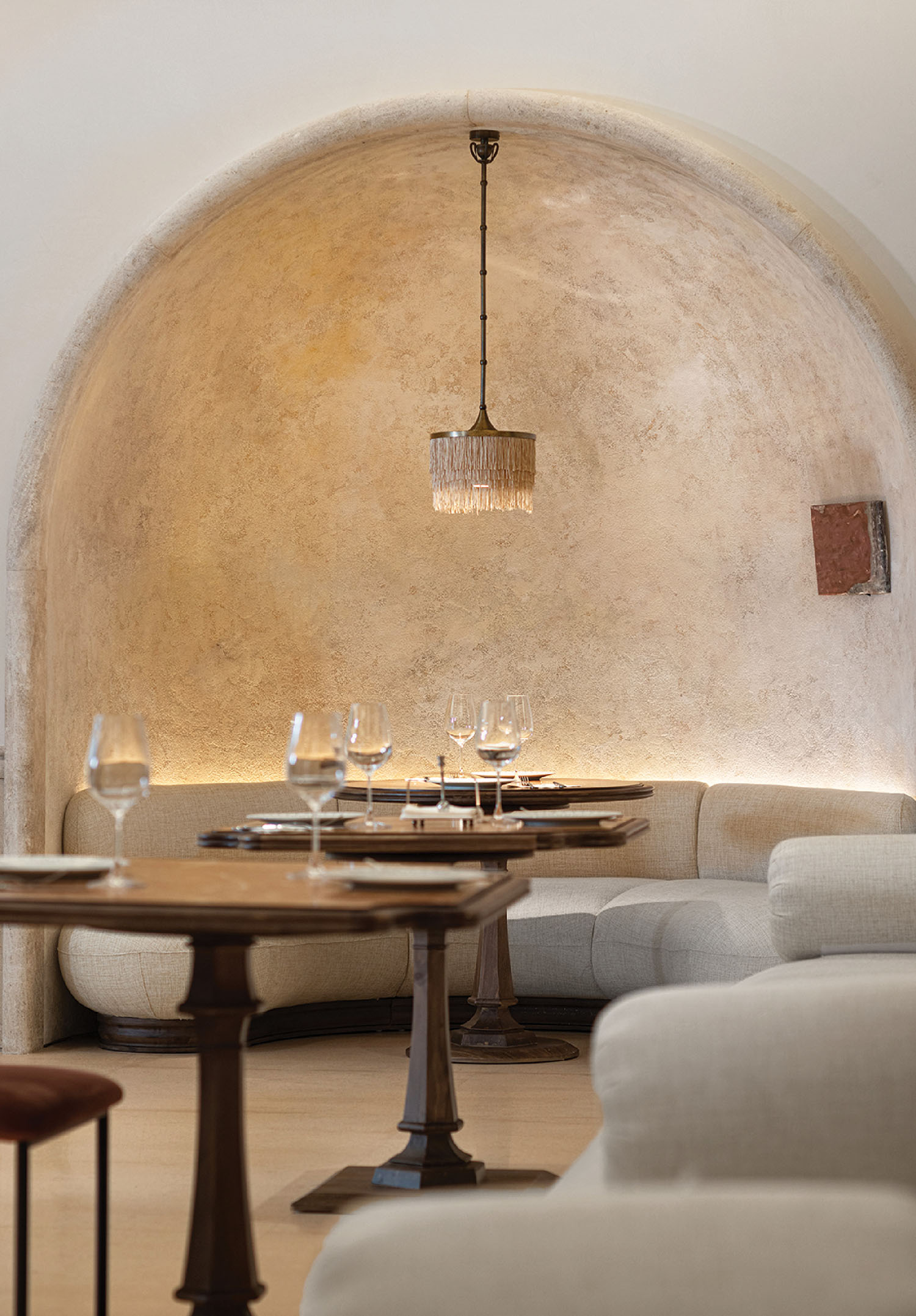 A table and chairs in a room with a wall.