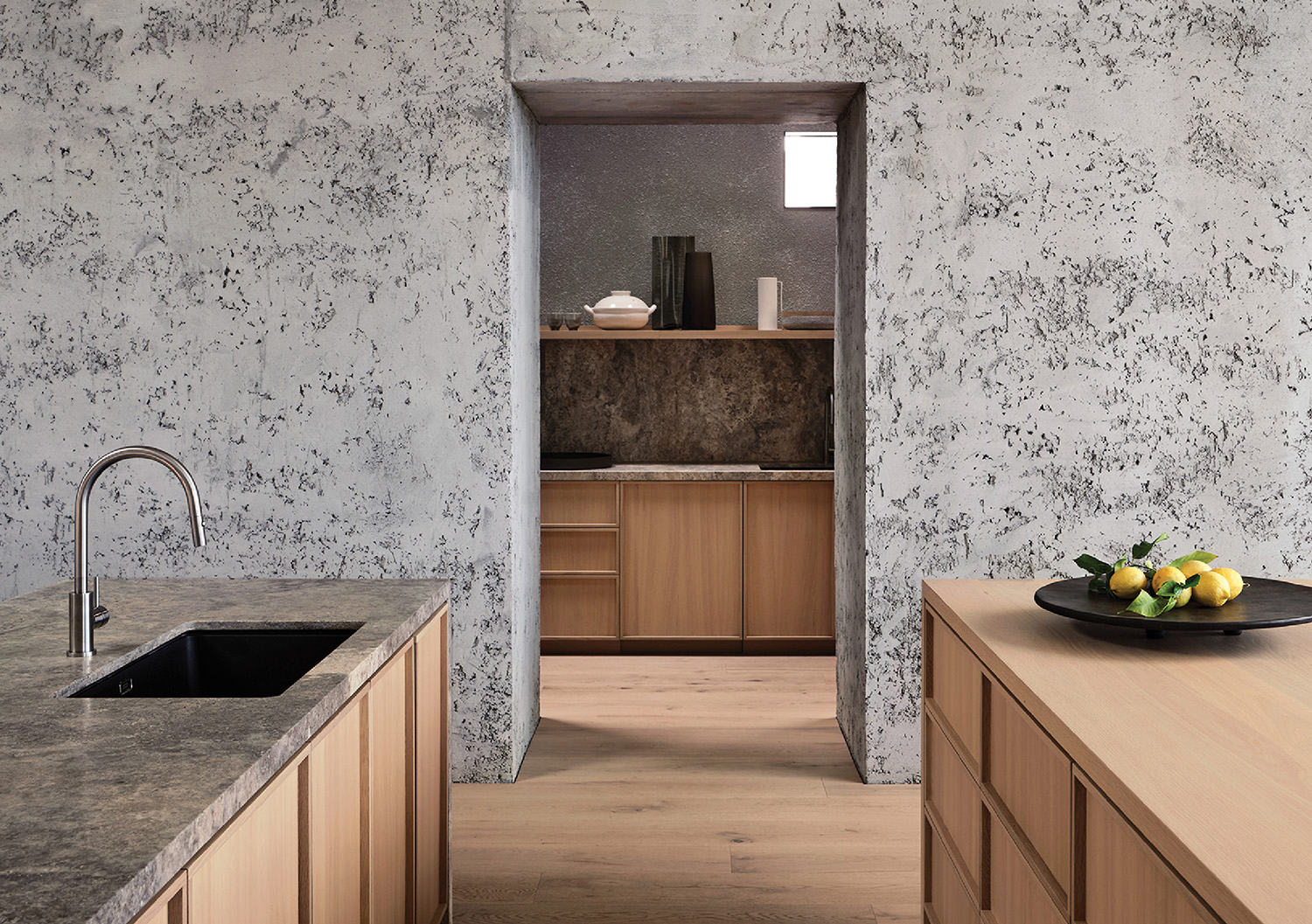 A kitchen with a sink and a bowl of fruit