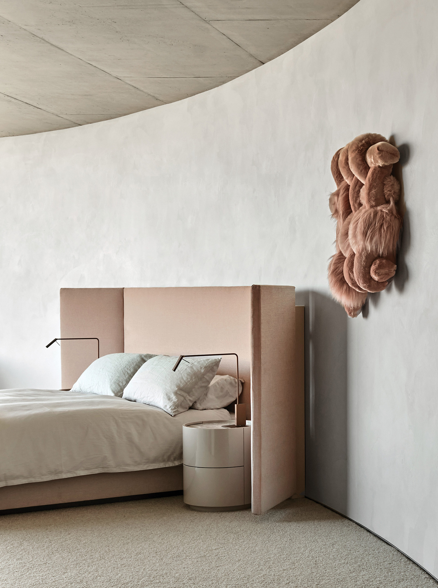 A bed with a teddy bear on the wall