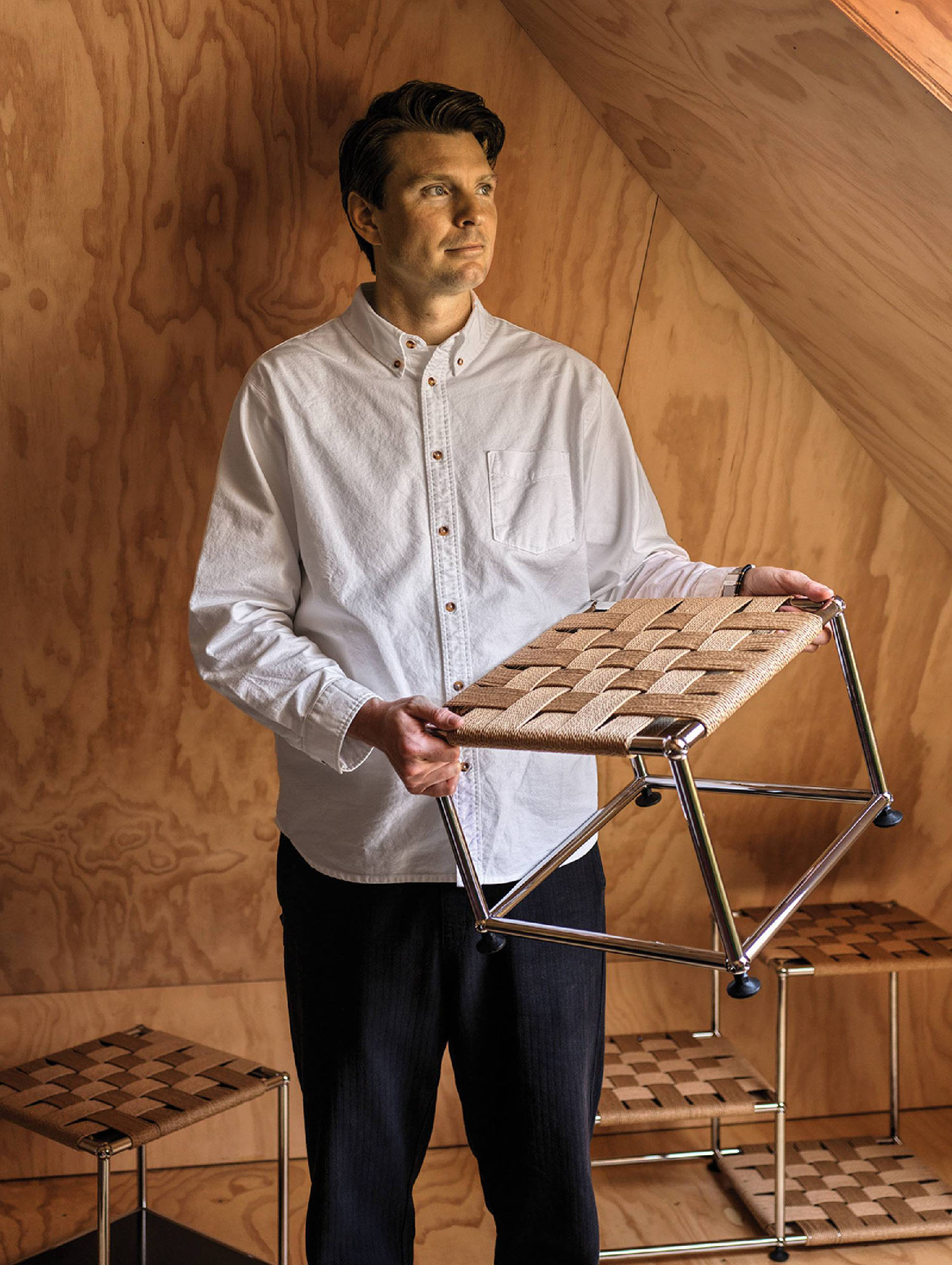 A man standing in front of a wooden wall.