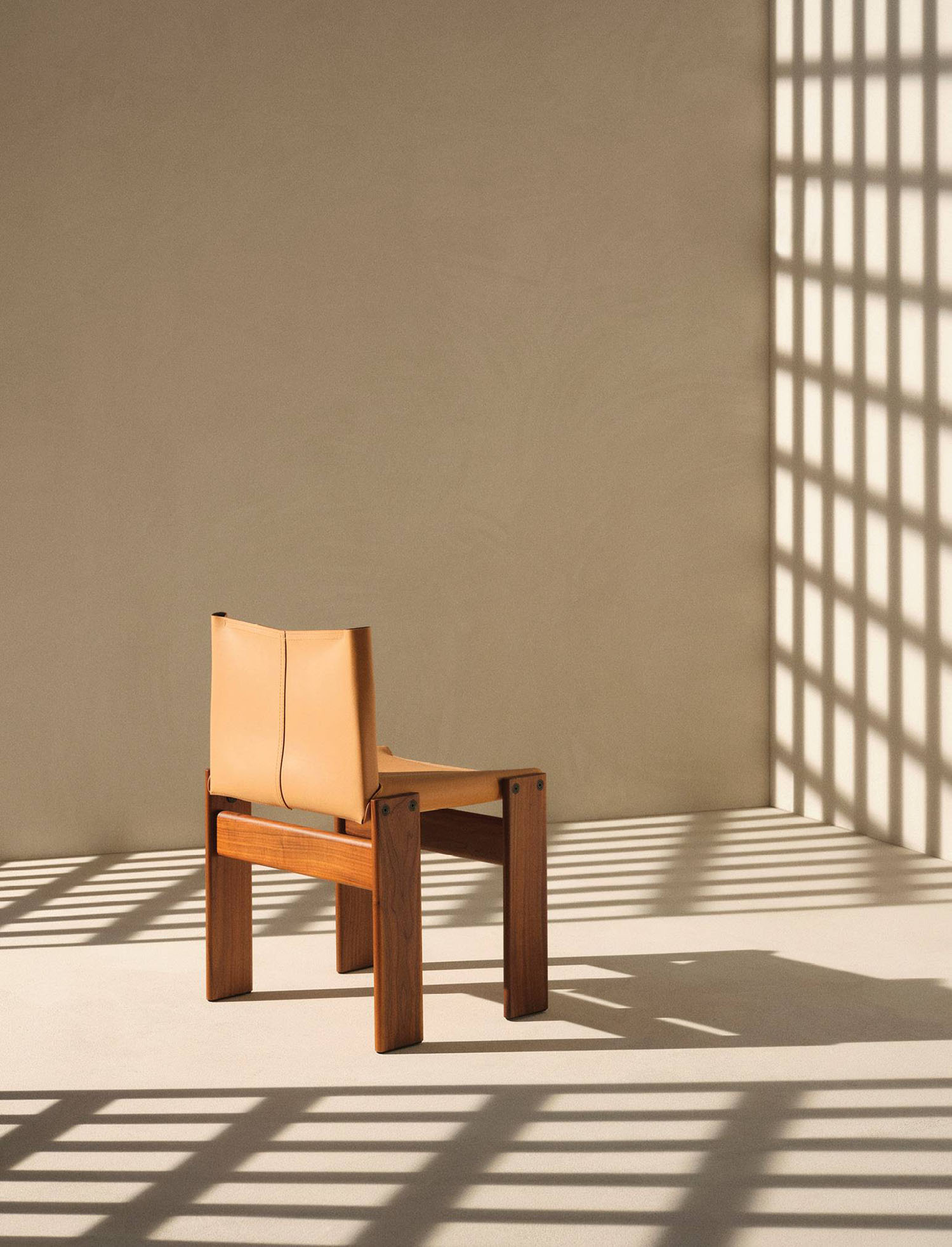A chair with a wooden seat in front of a wall.