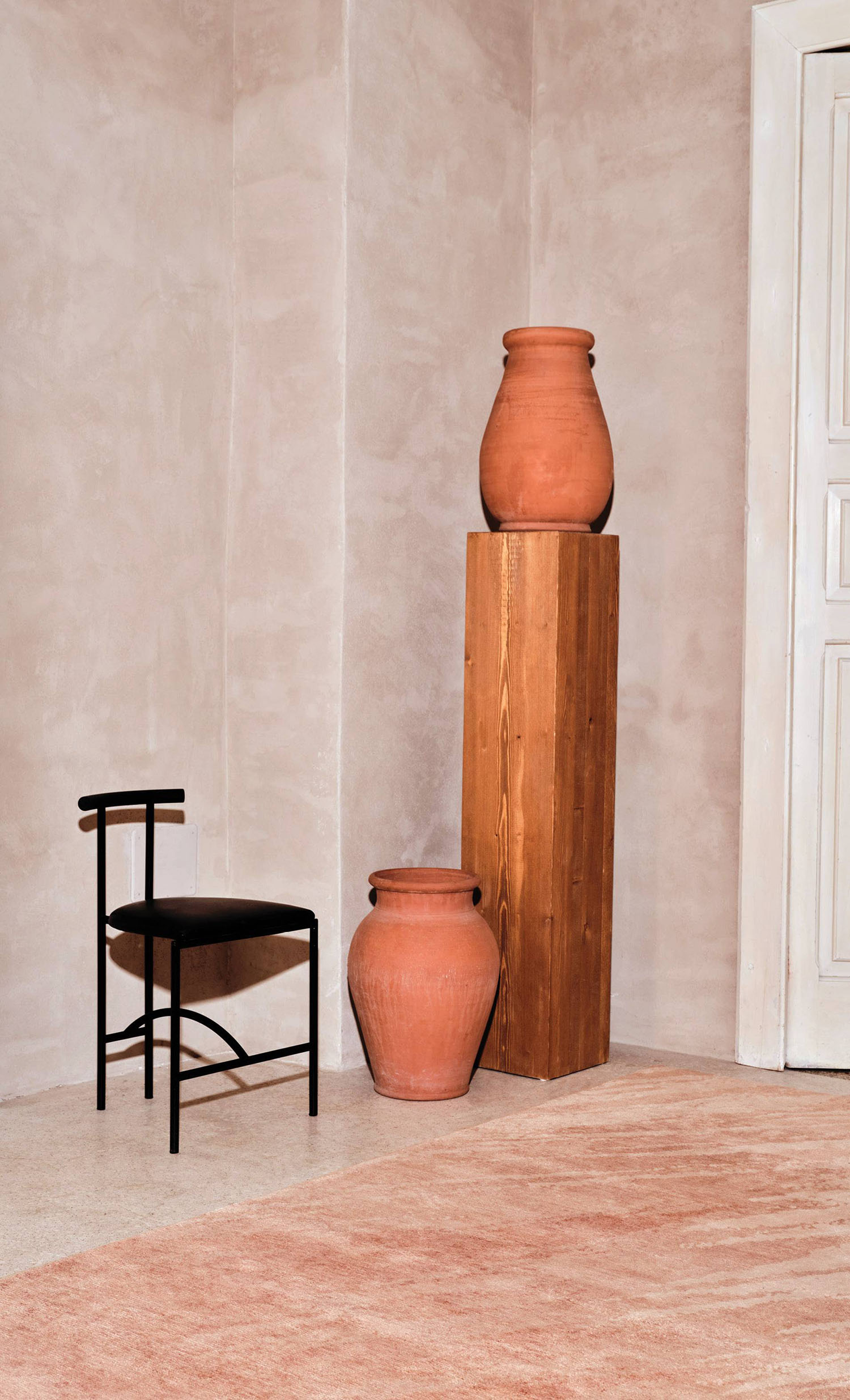 A chair and a vase in a room.