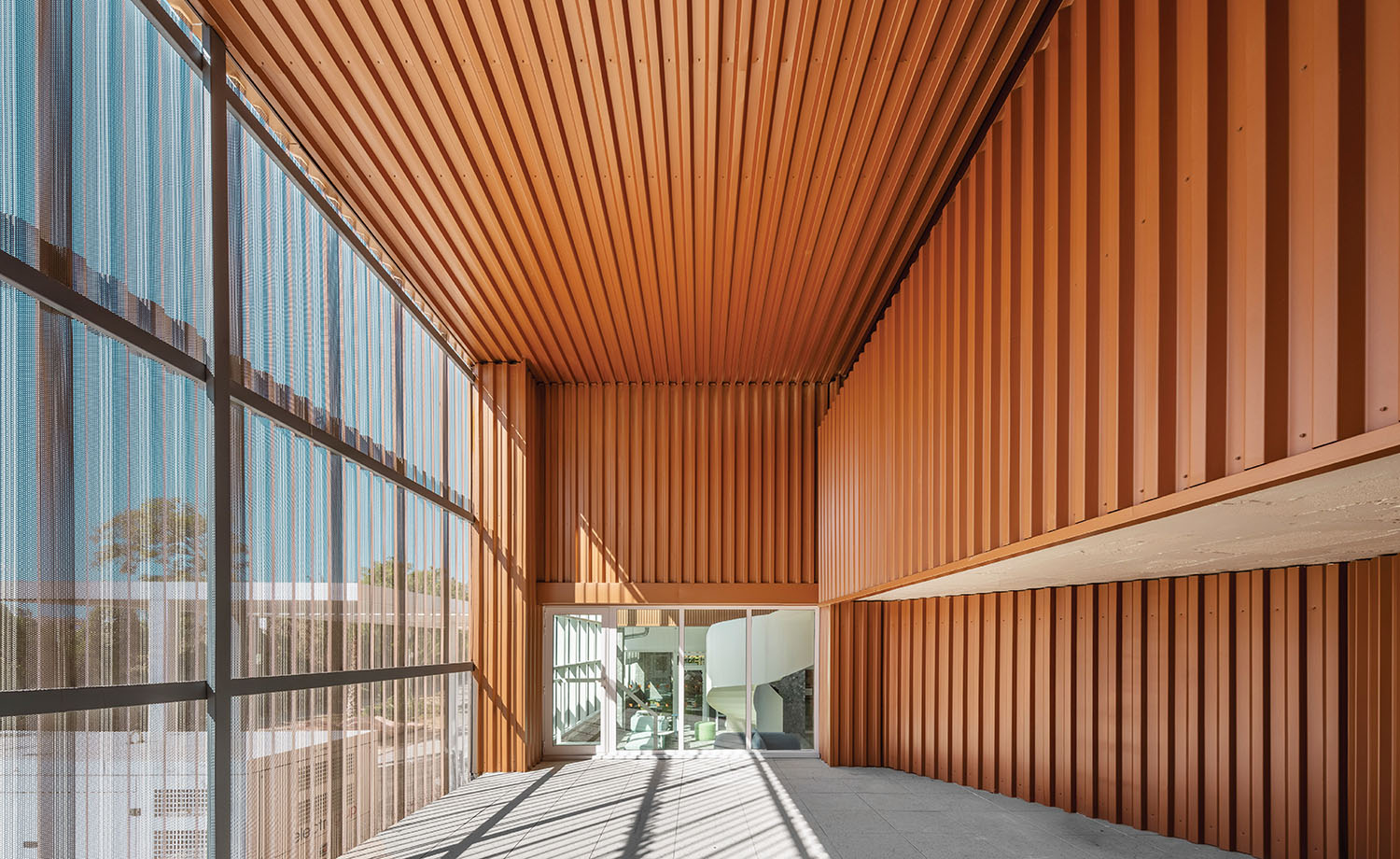 a long walkway with a wooden wall and a glass window