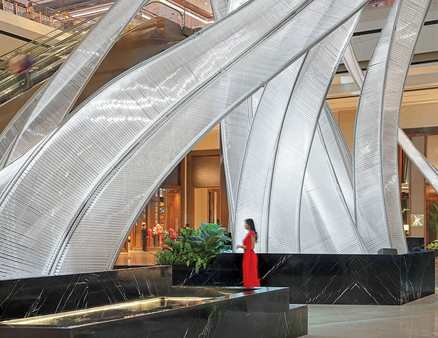 A woman in a red dress is walking through a lobby