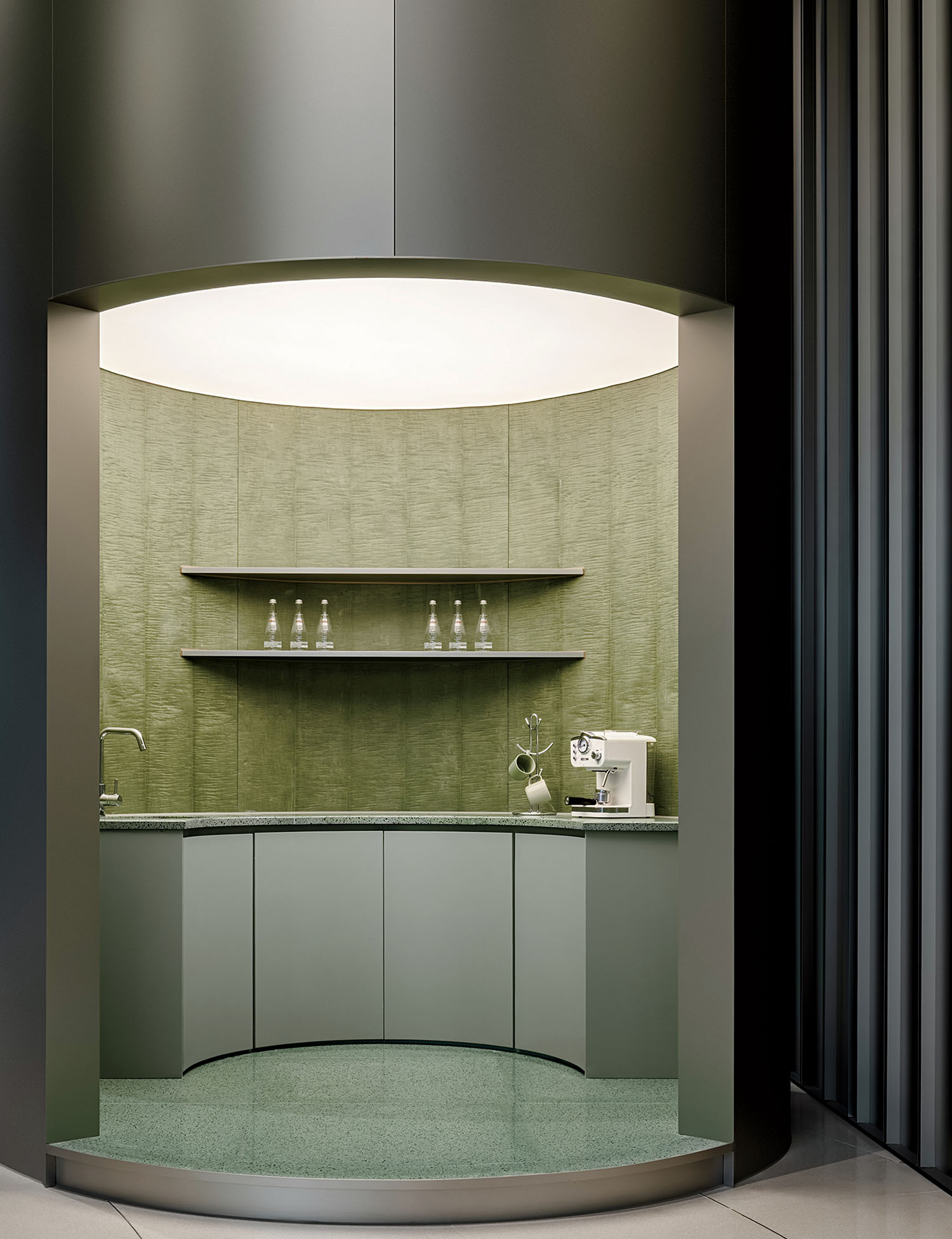 A kitchen with a green wall and a white sink.