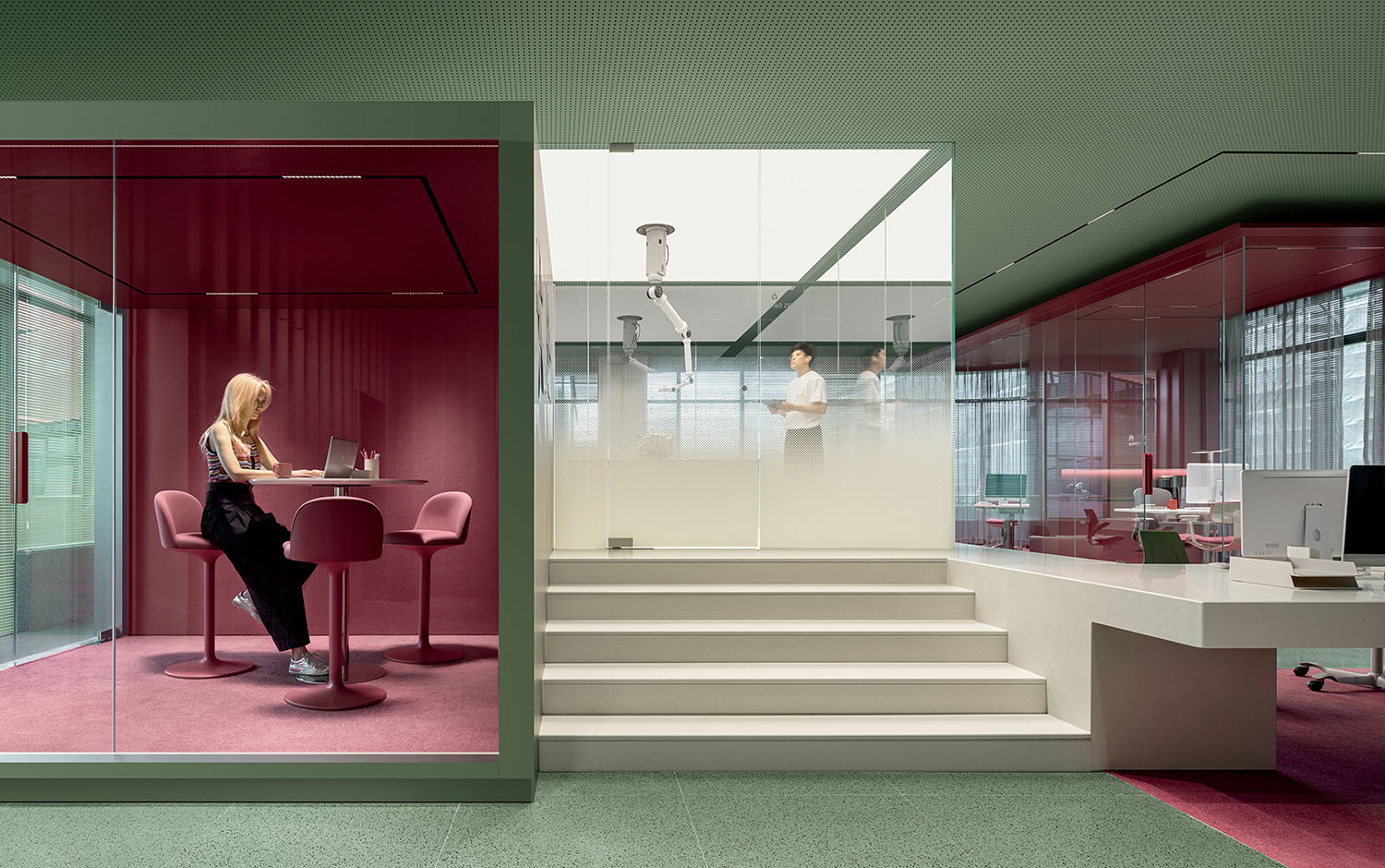 A woman sitting in a pink chair in a room.