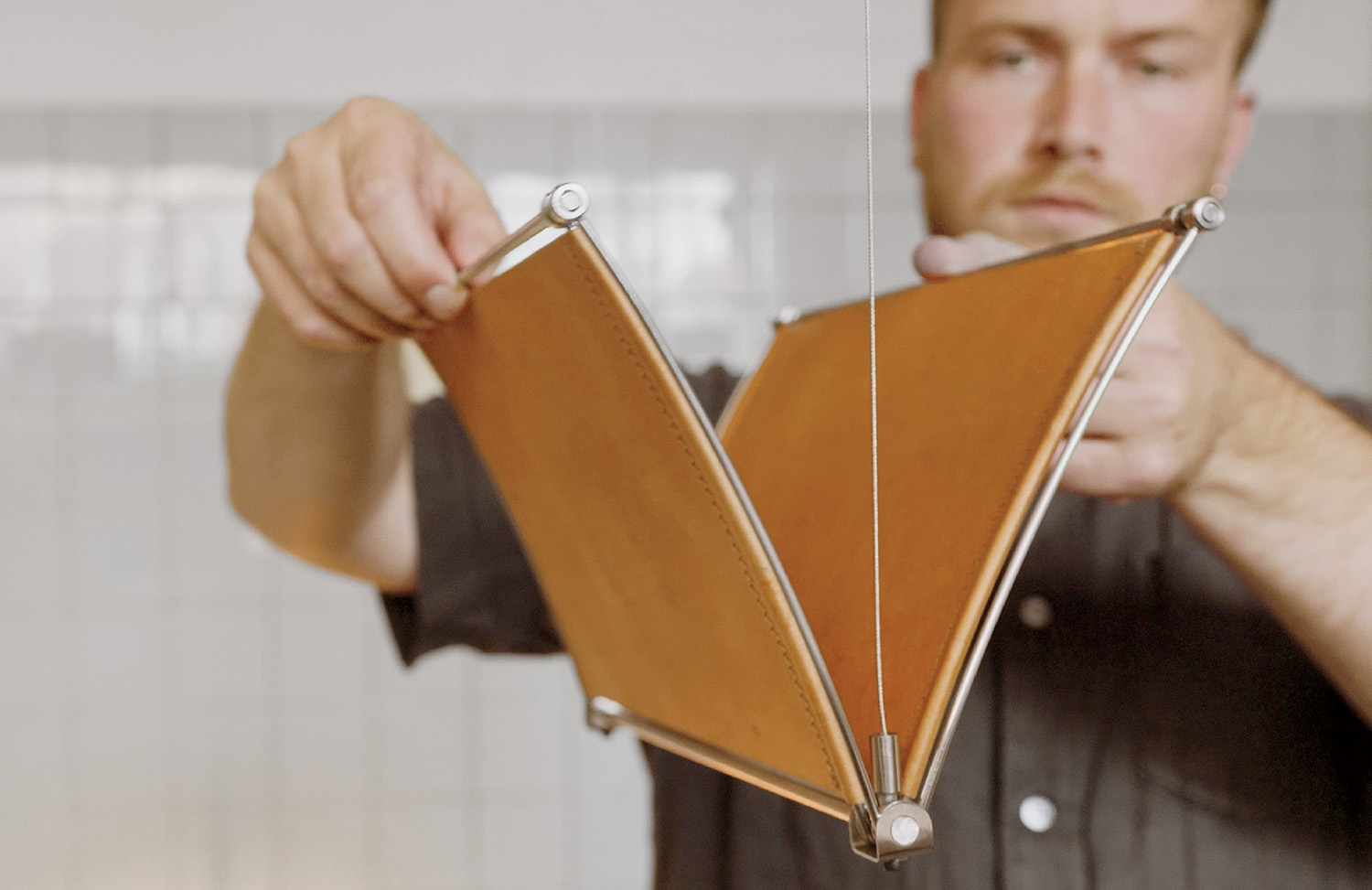 A man holding a piece of wood with a string attached to it