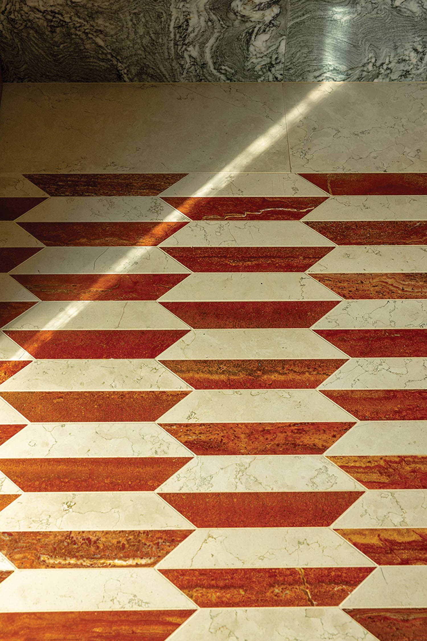 A bathroom with a red and white tile floor.