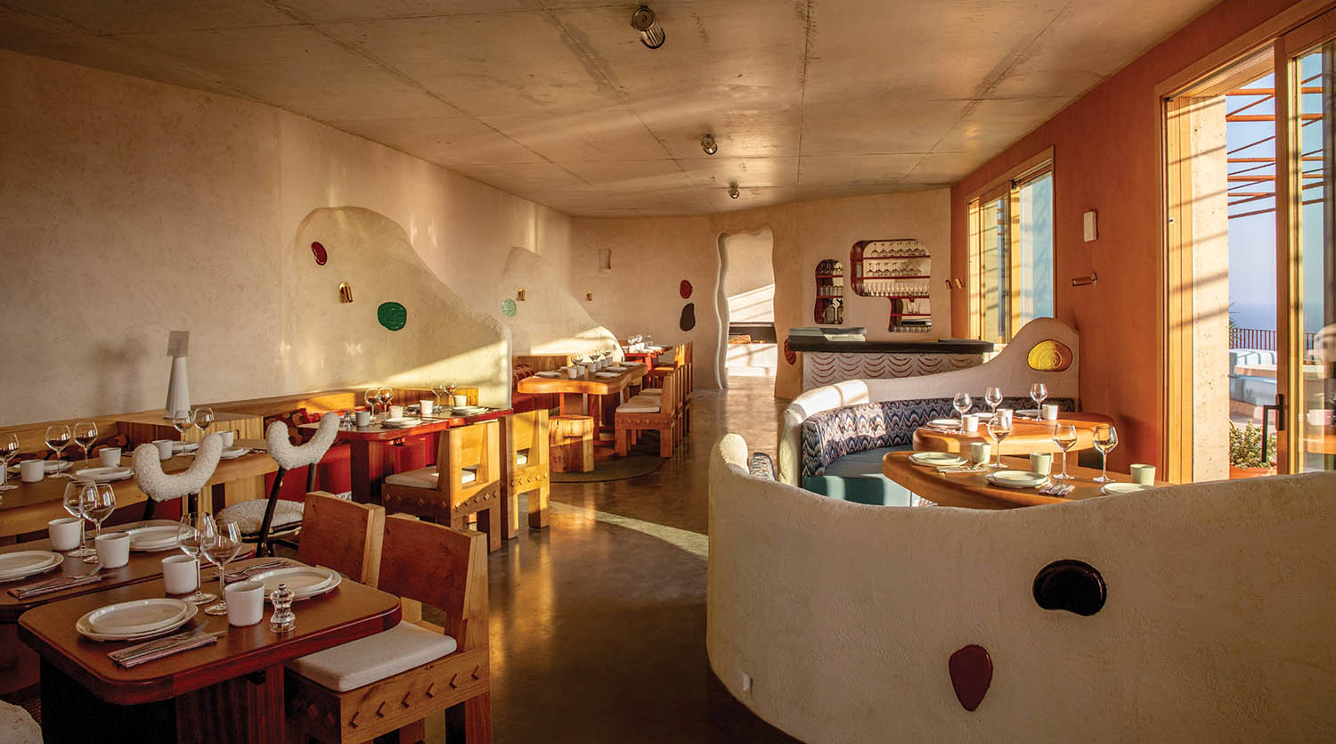 A room with a table and chairs and a kitchen.