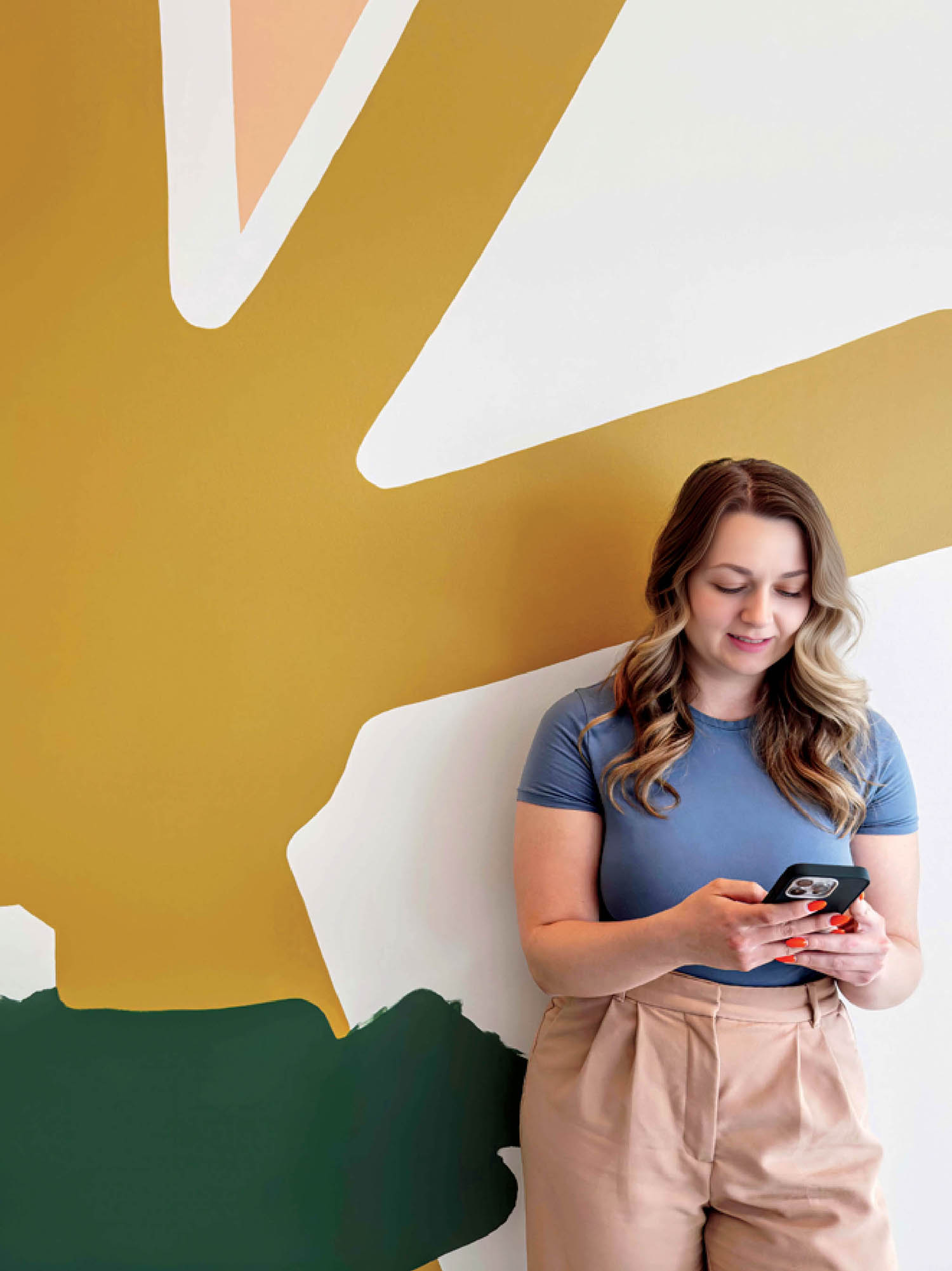 A woman standing in front of a wall with a cell