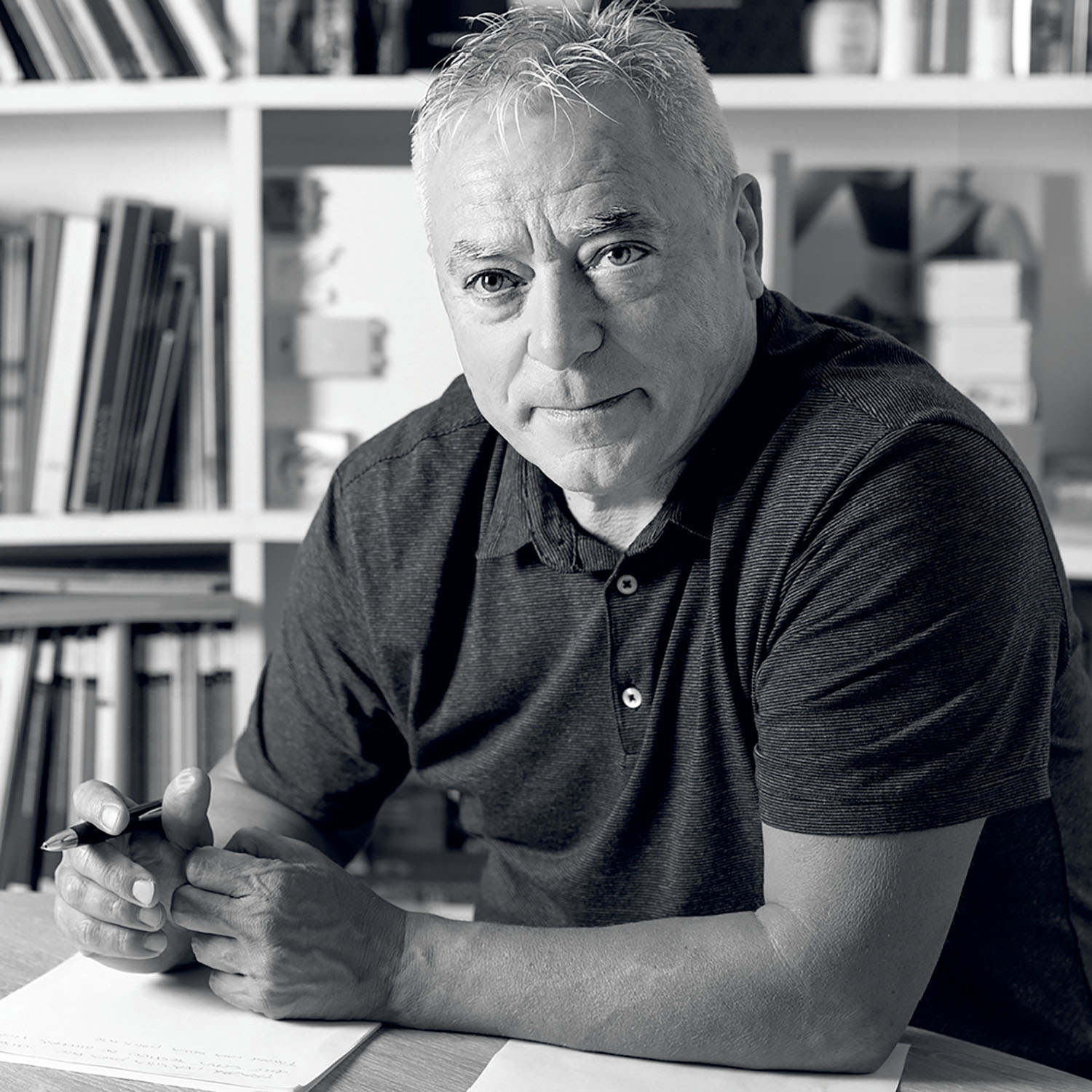 A man sitting at a table with a pen and paper.