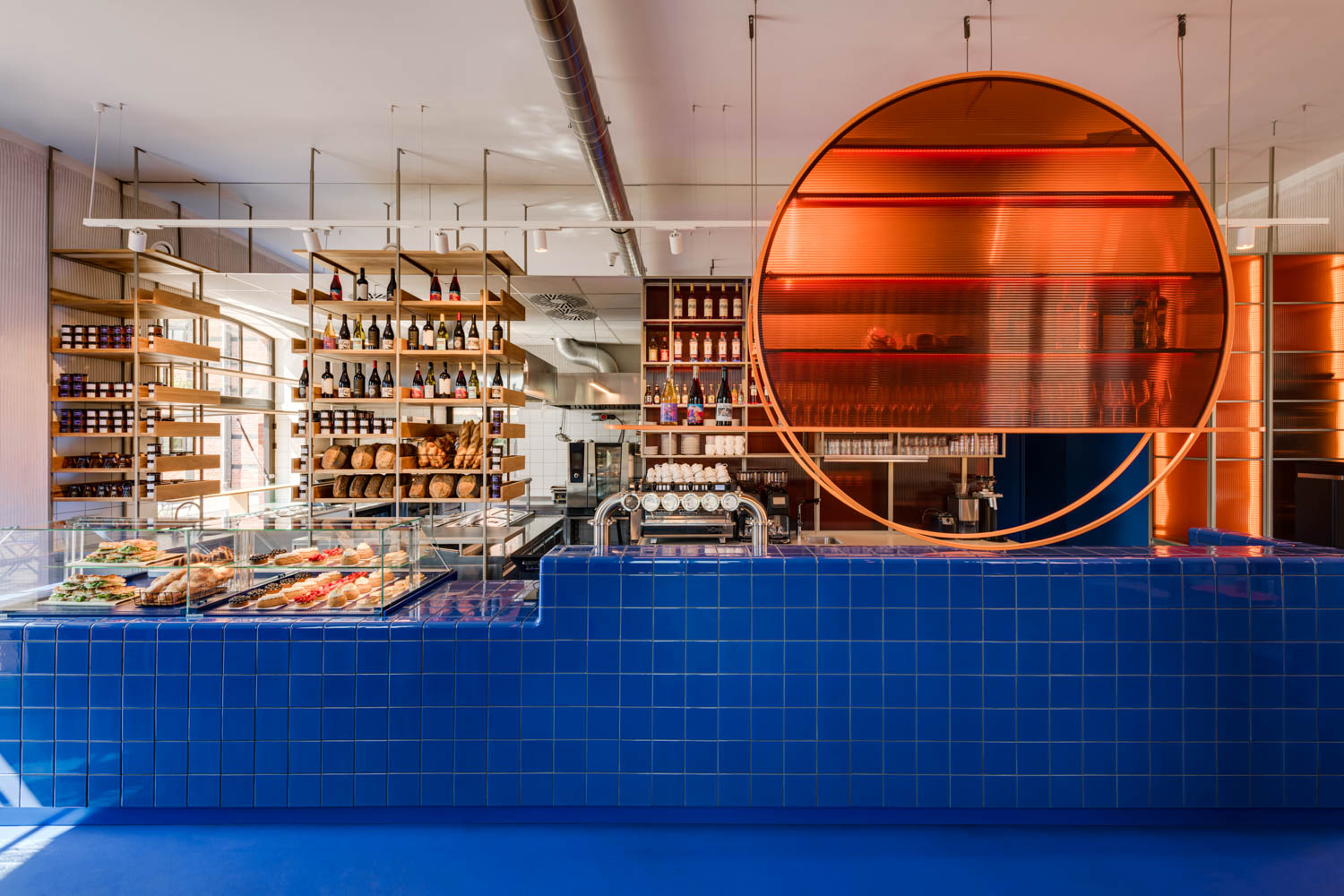 orange circular shelving hangs above a blue countertop