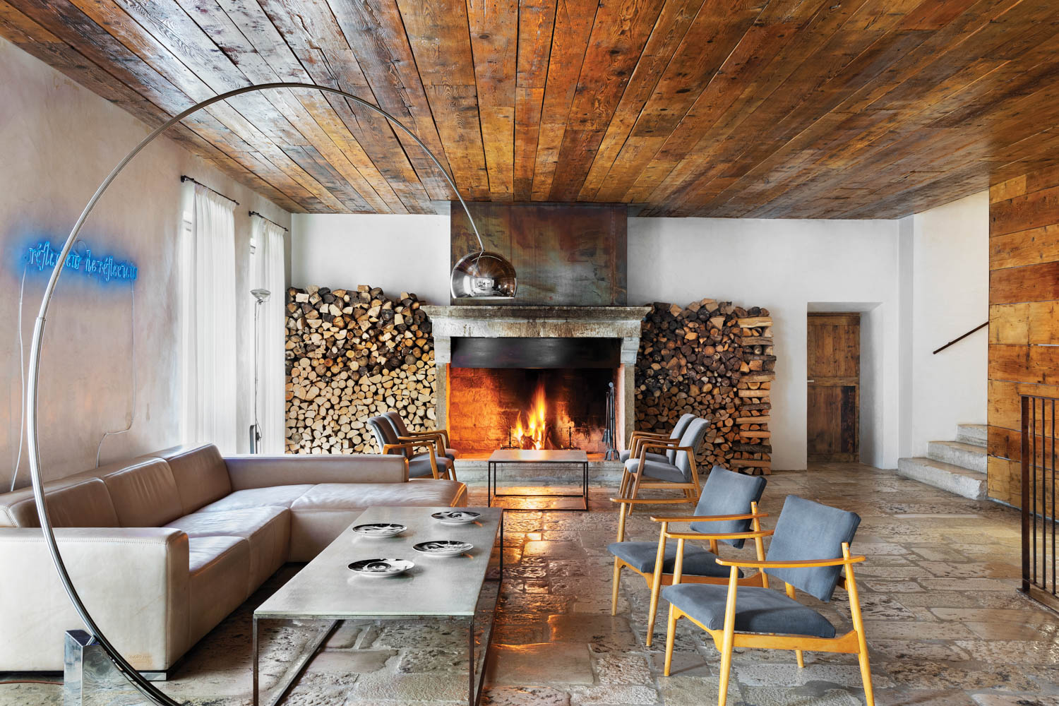 a neon sign and fireplace light up the lounge at this hotel