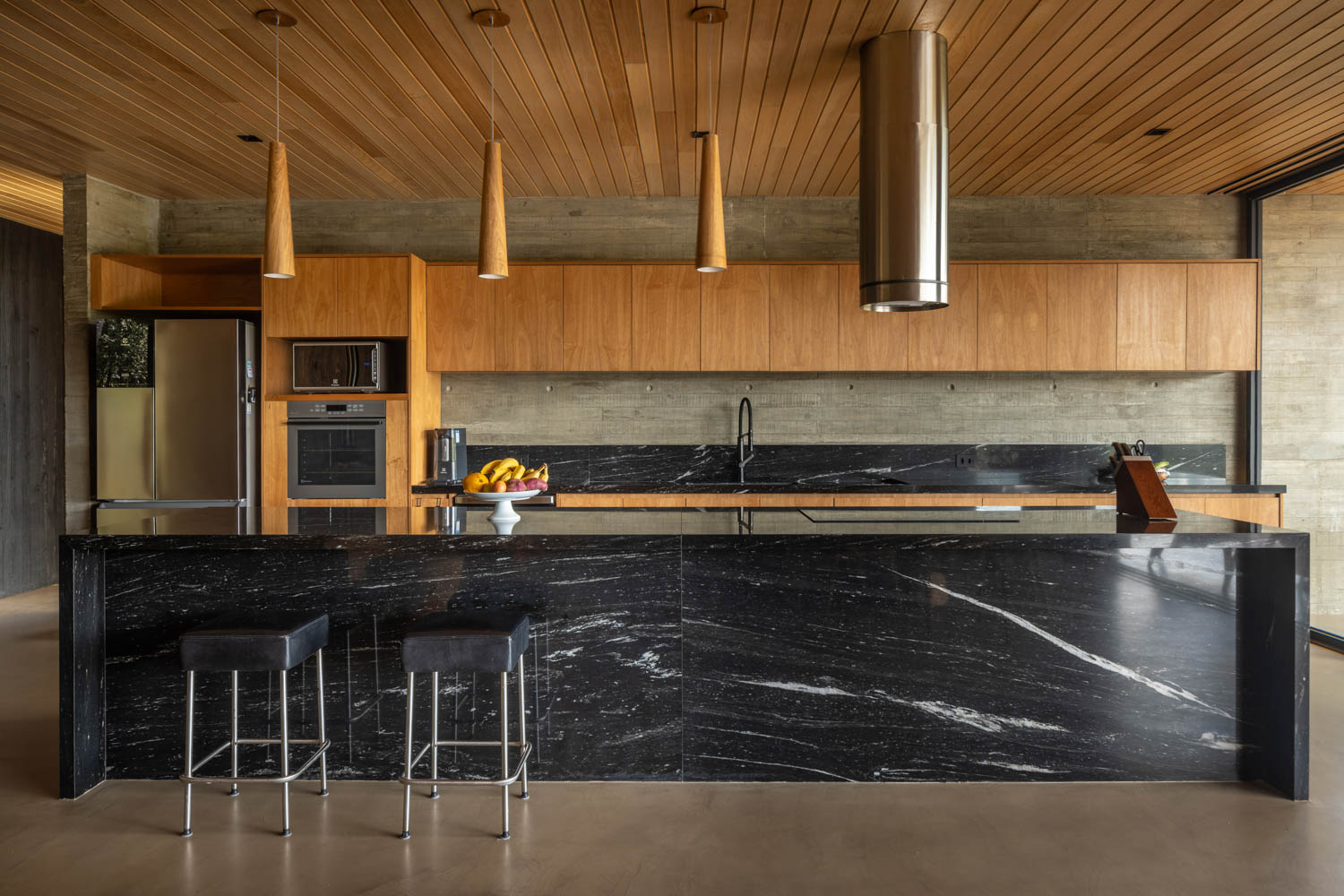 kitchen with wood cabinetry and all black marble island