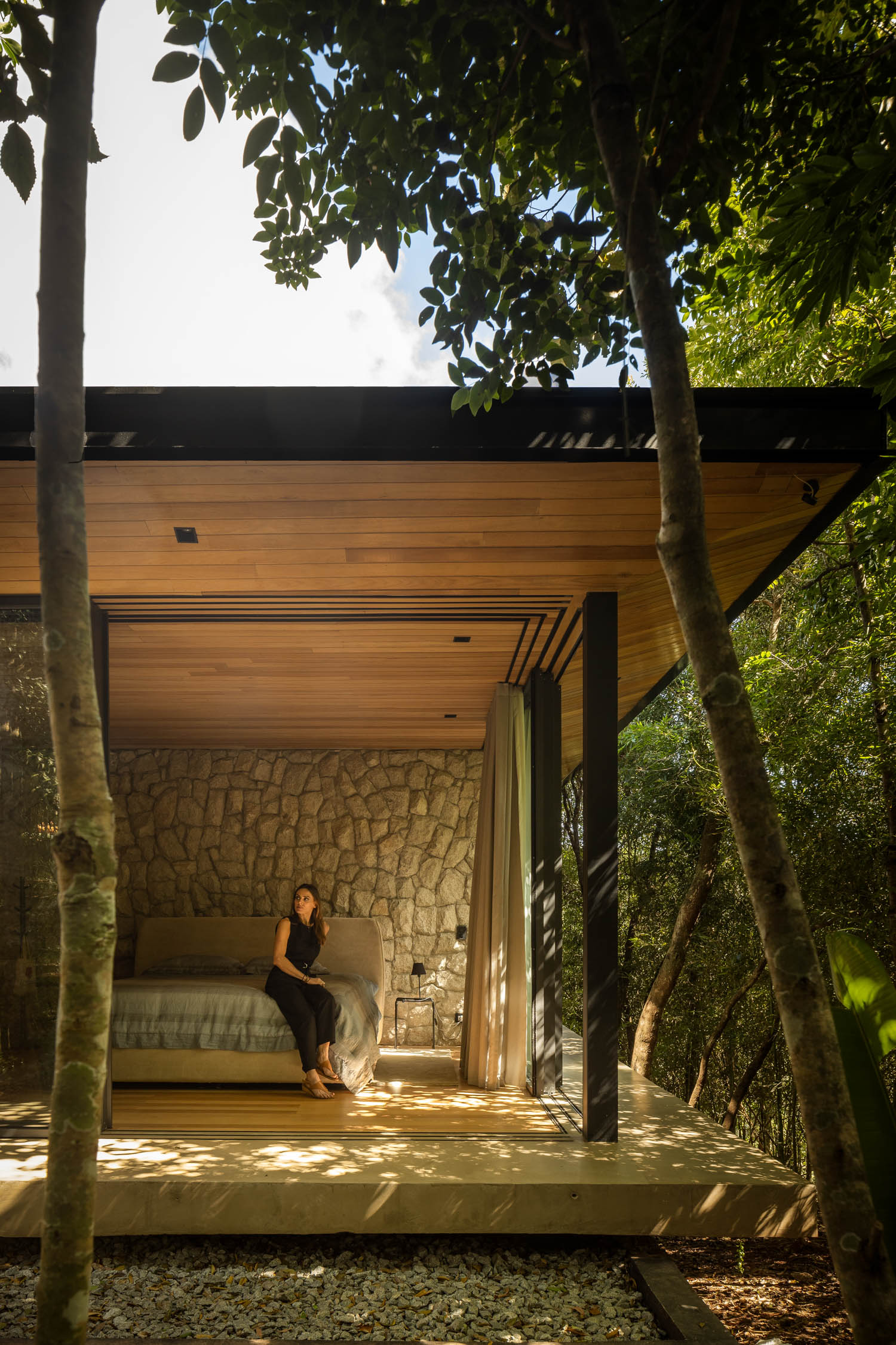 bedroom with glass windows and view of the surrounding forest