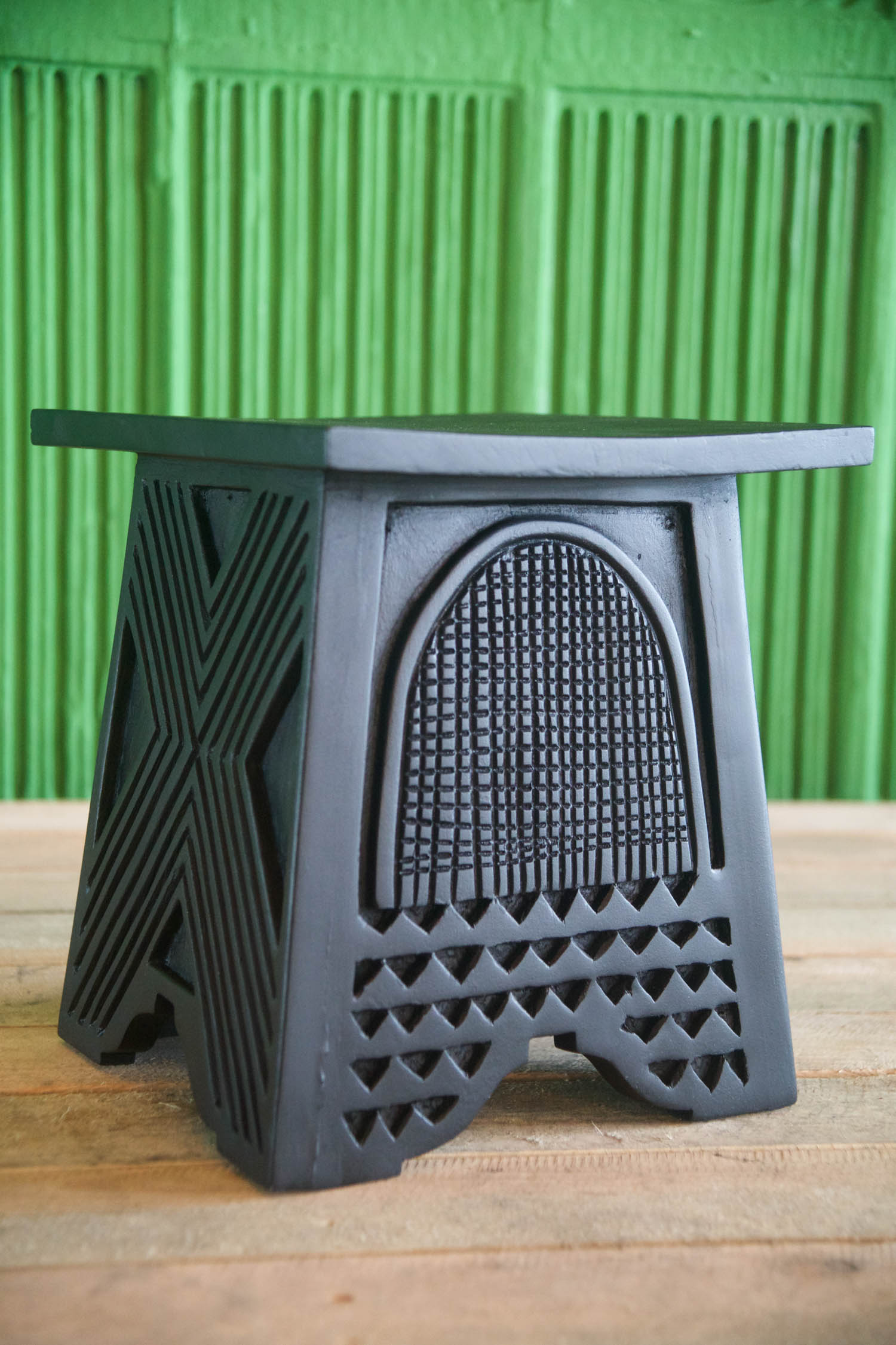 black stool with engravings in a room