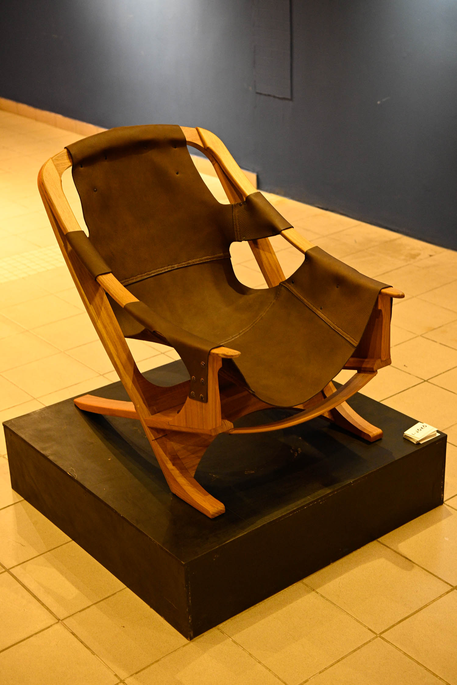 brown chair with patches on a black platform