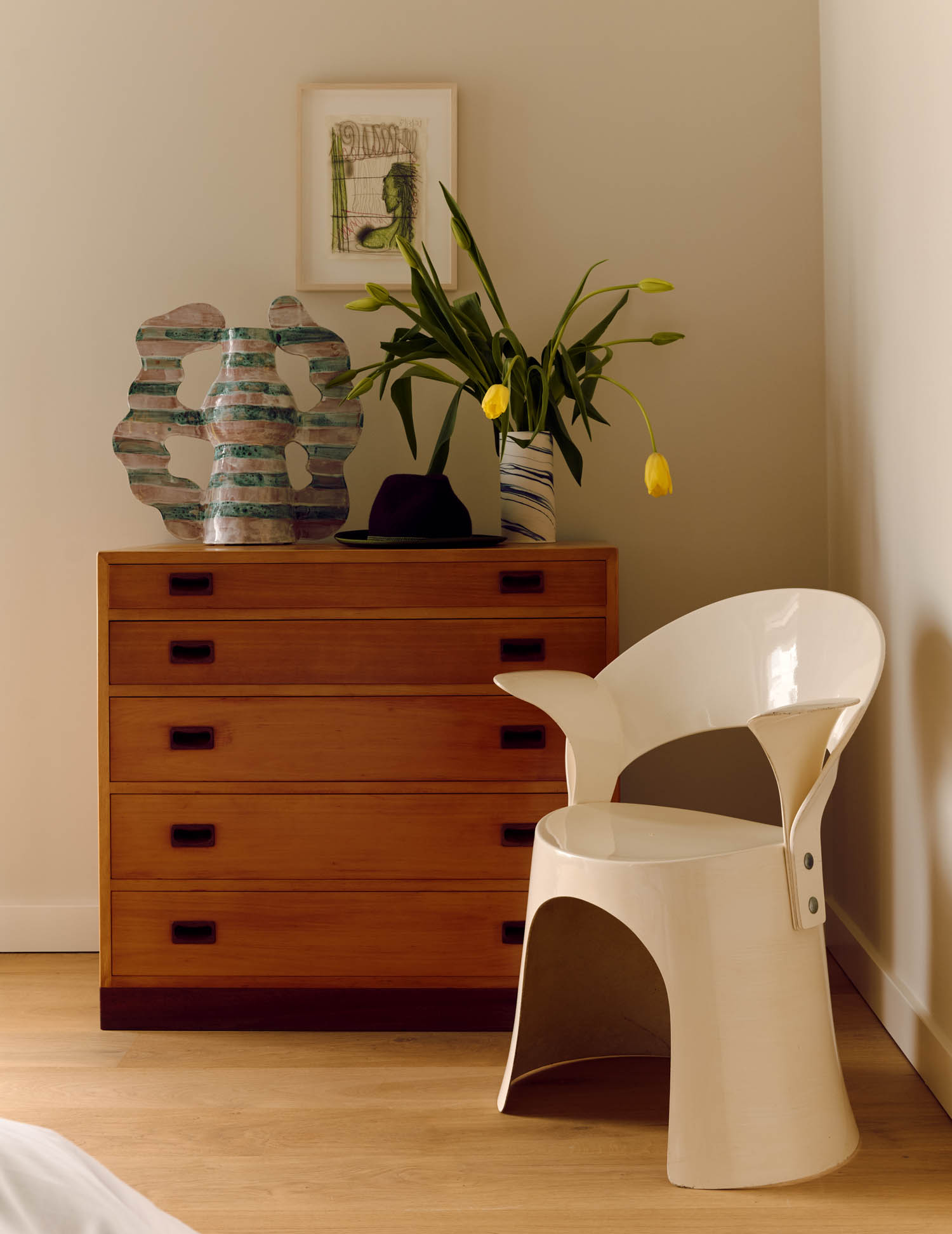 corner of bedroom with wooden wardrobe and white chair