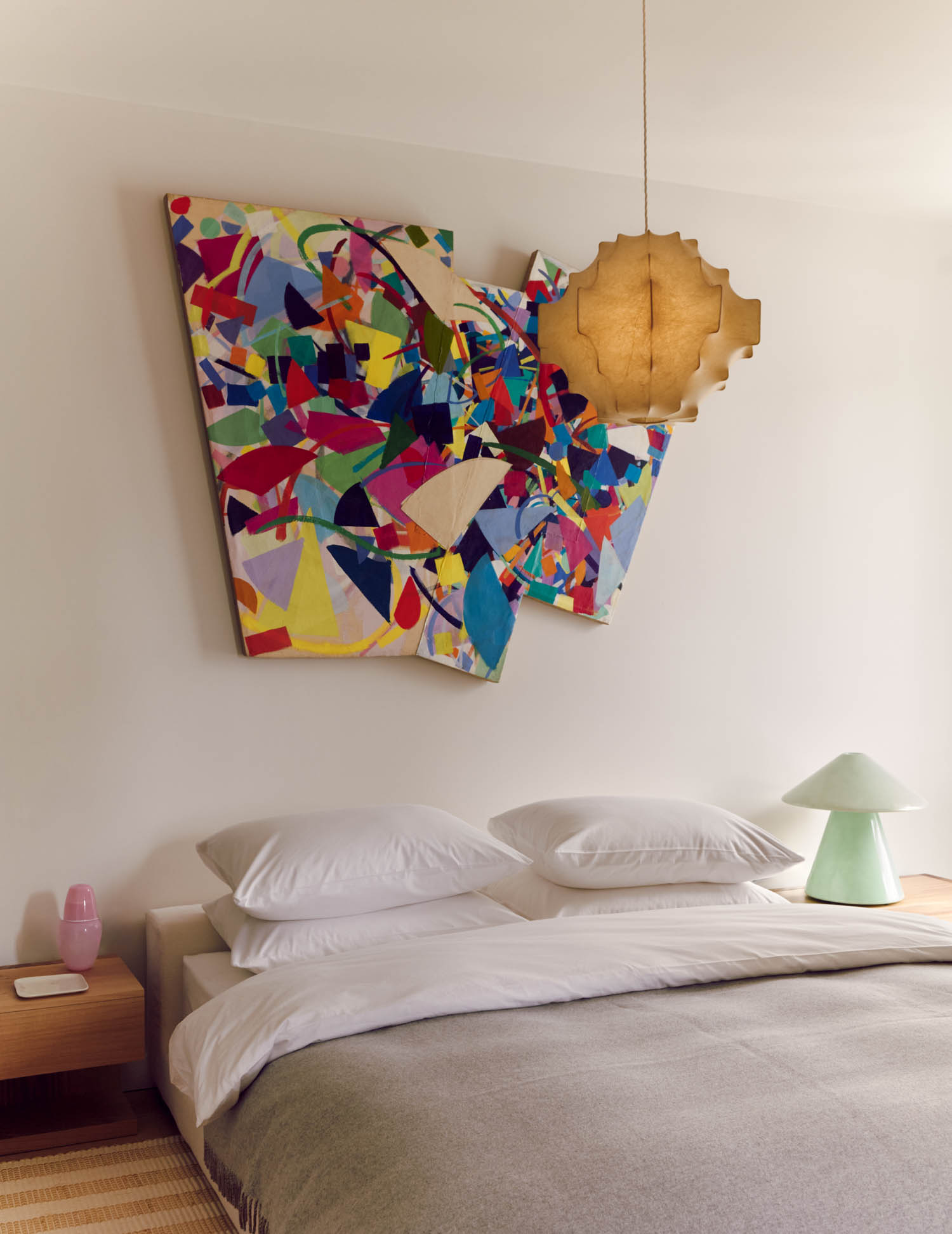 pendant light overlooking a bedroom with bright artwork
